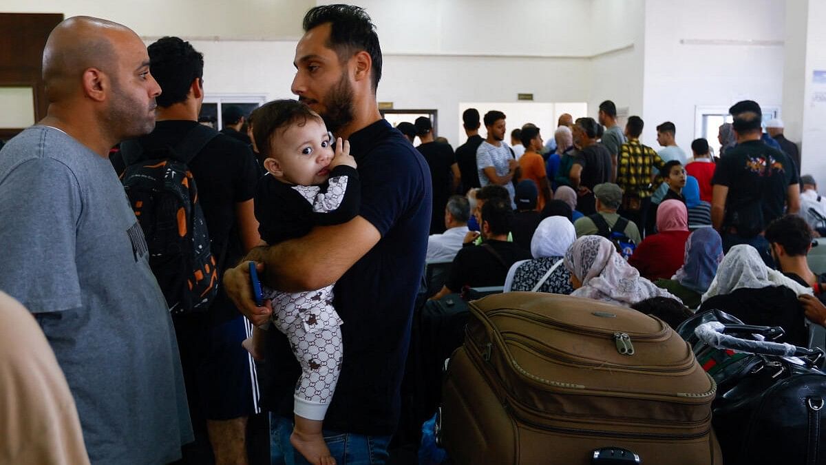 <div class="paragraphs"><p>Palestinians with foreign passports wait for permission to leave Gaza, amid the ongoing conflict between Israel and Palestinian Islamist group Hamas, at the Rafah border crossing with Egypt, in Rafah in the southern Gaza Strip, November 7, 2023.</p></div>