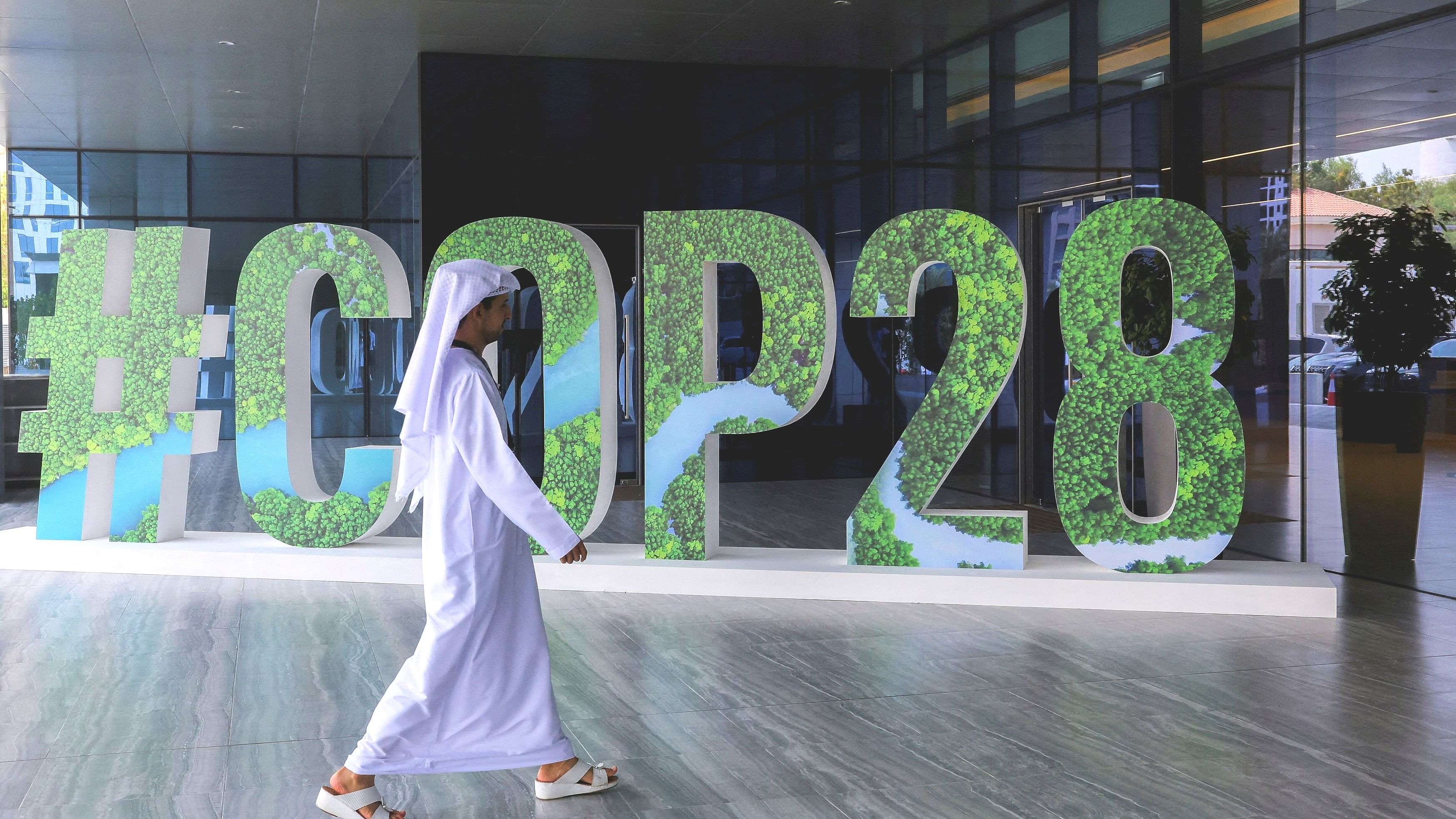 <div class="paragraphs"><p>FILE PHOTO: A person walks past a "#COP28" sign during The Changemaker Majlis in Abu Dhabi, United Arab Emirates.</p></div>