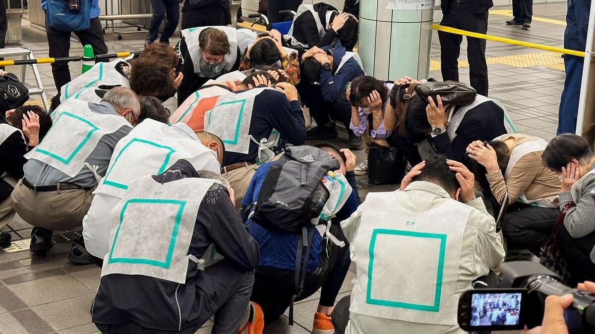 <div class="paragraphs"><p>Drill participants cover their heads in a designated area inside Nerima train station in Tokyo, Japan November 6, 2023.</p></div>