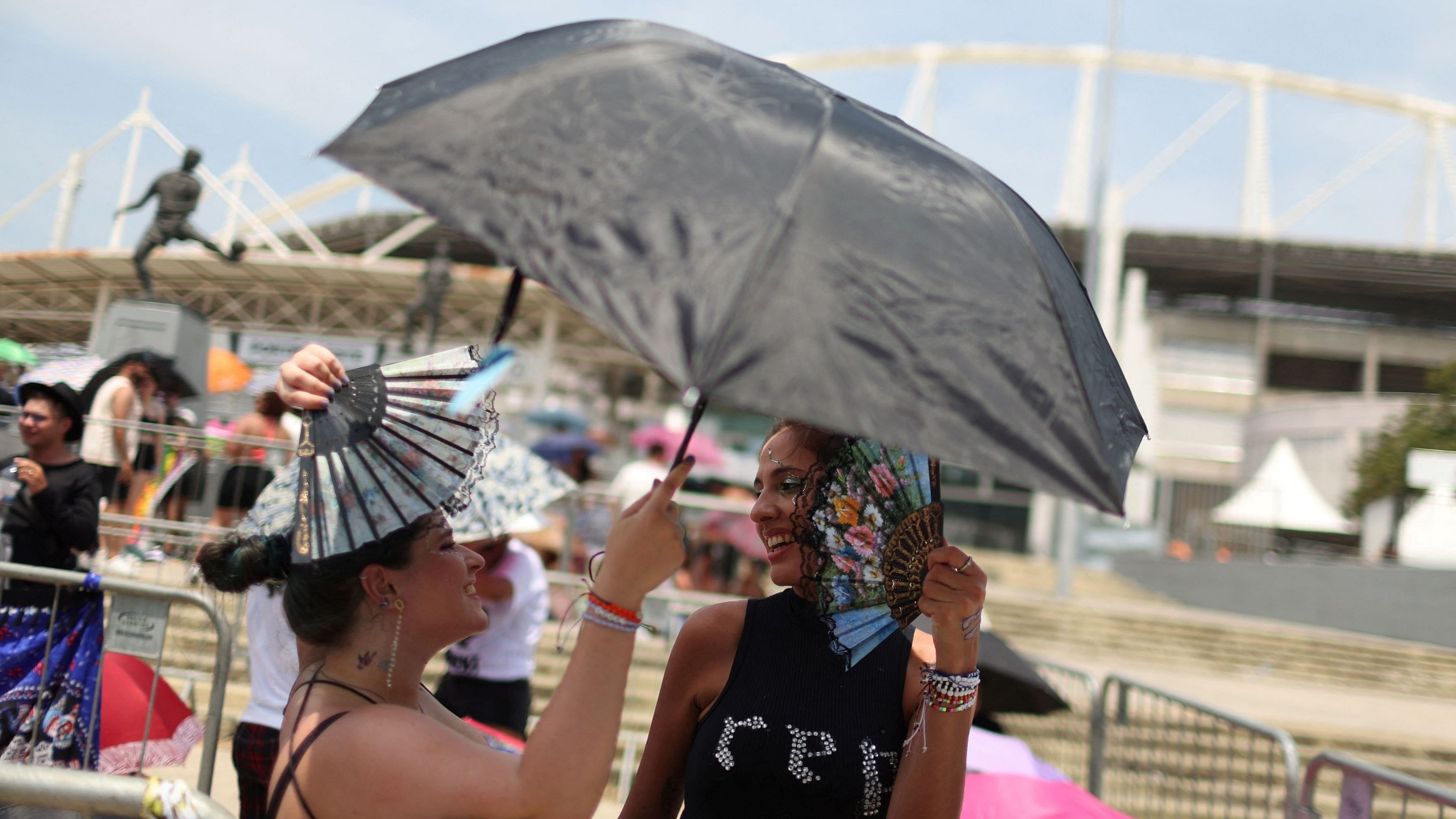 <div class="paragraphs"><p>Women use an umbrella to protect themselves from the sun, as they wait for the Taylor Swift concert, following the death of a fan due to the heat during the first day concert, in Rio de Janeiro, Brazil, November 18, 2023. </p></div>