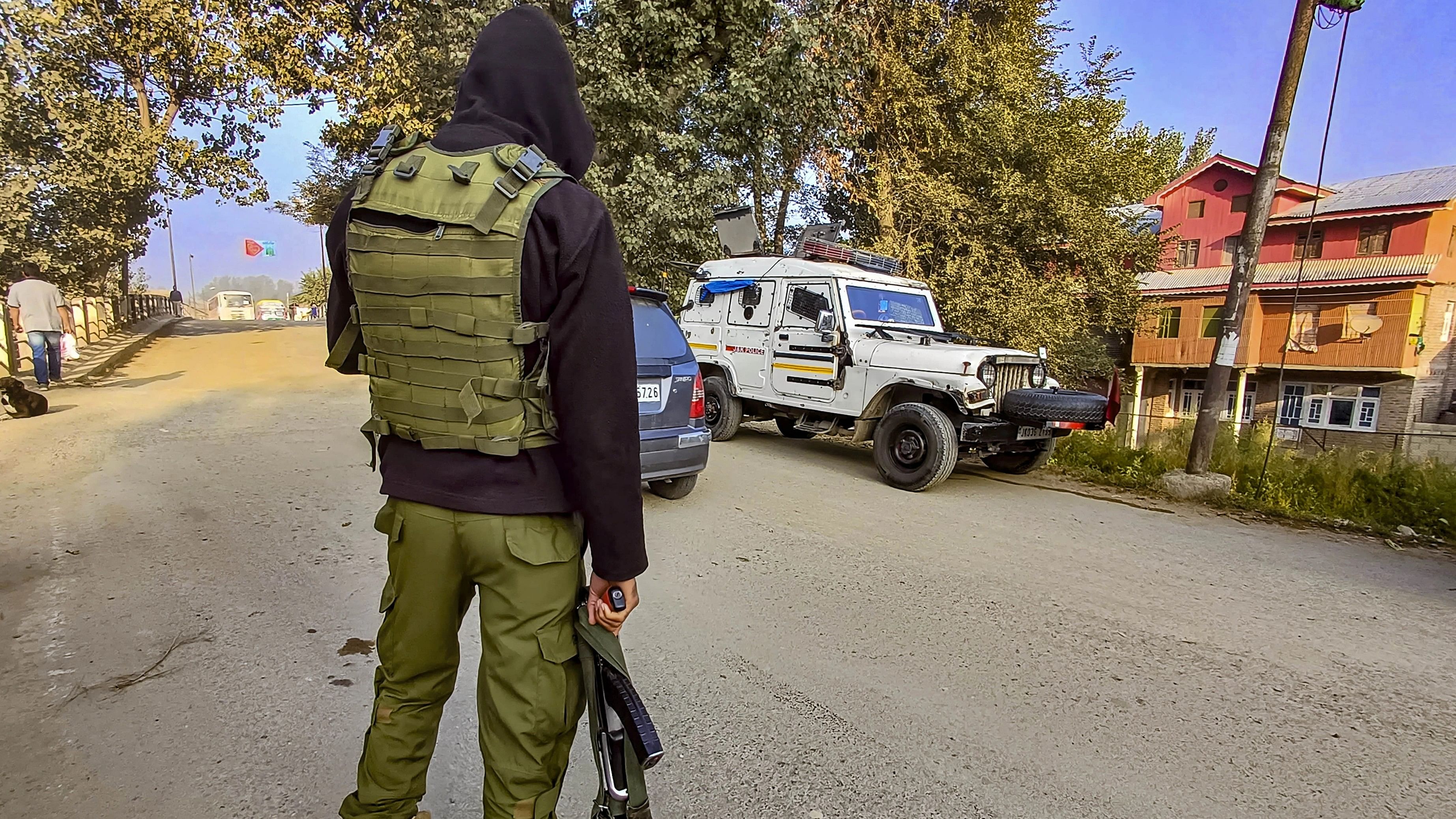 <div class="paragraphs"><p>A security personnel stands guard during J&amp;K SIA's raids.</p></div>