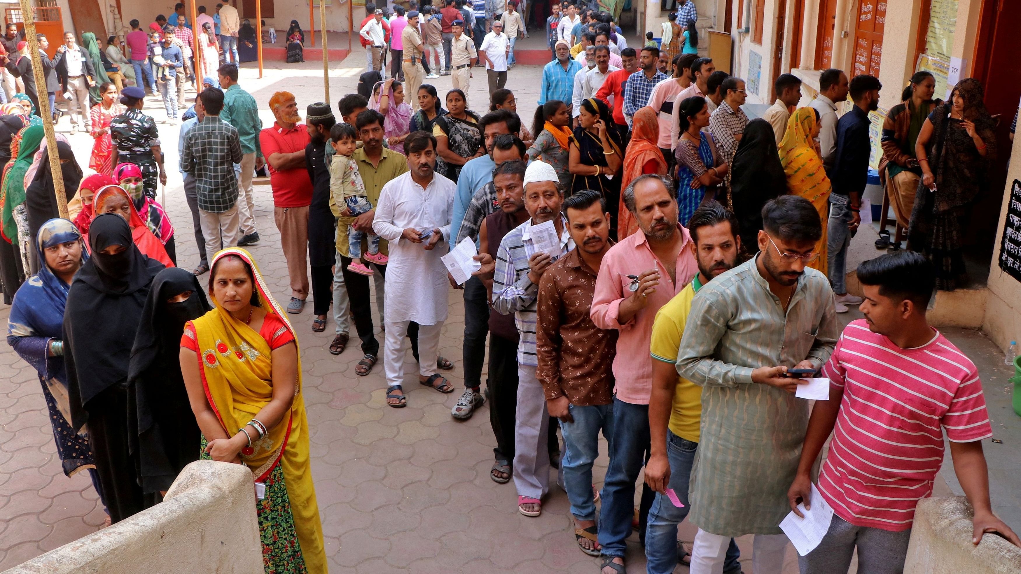 <div class="paragraphs"><p>People wait in queues to cast their votes at a polling station during the Madhya Pradesh state assembly election.</p></div>