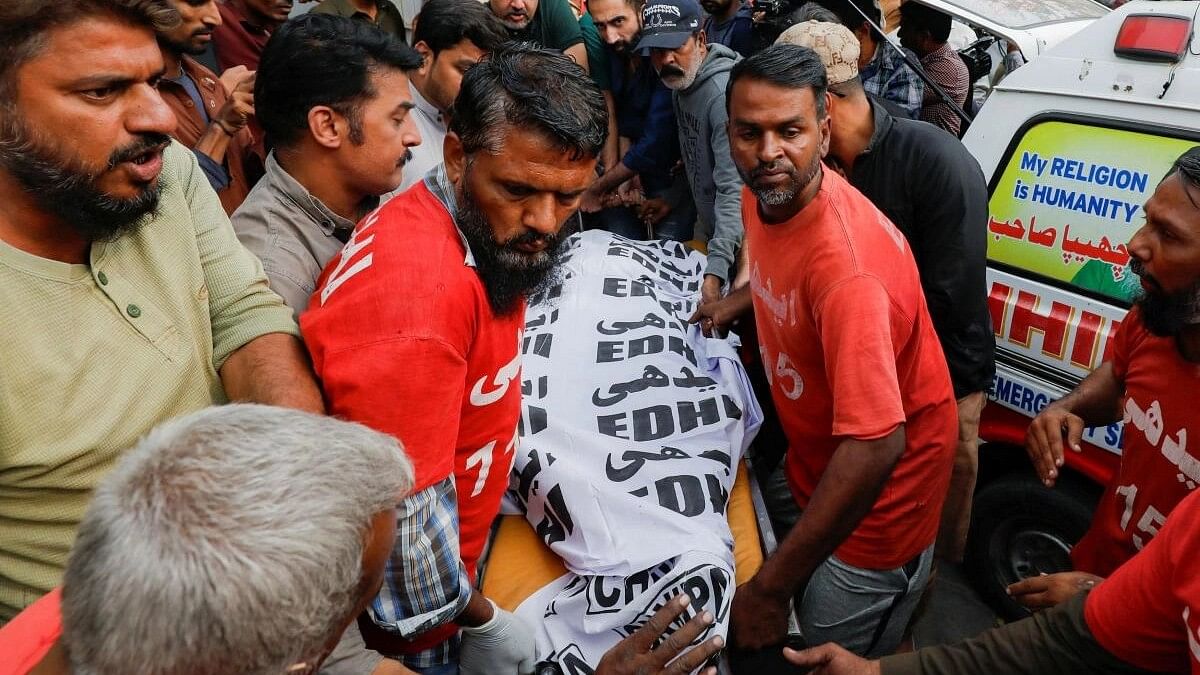 <div class="paragraphs"><p>Rescue workers move the body of a man, who along with others was killed, after a fire broke out at a multi-story shopping mall, outside at a hospital morgue in Karachi.&nbsp;</p></div>