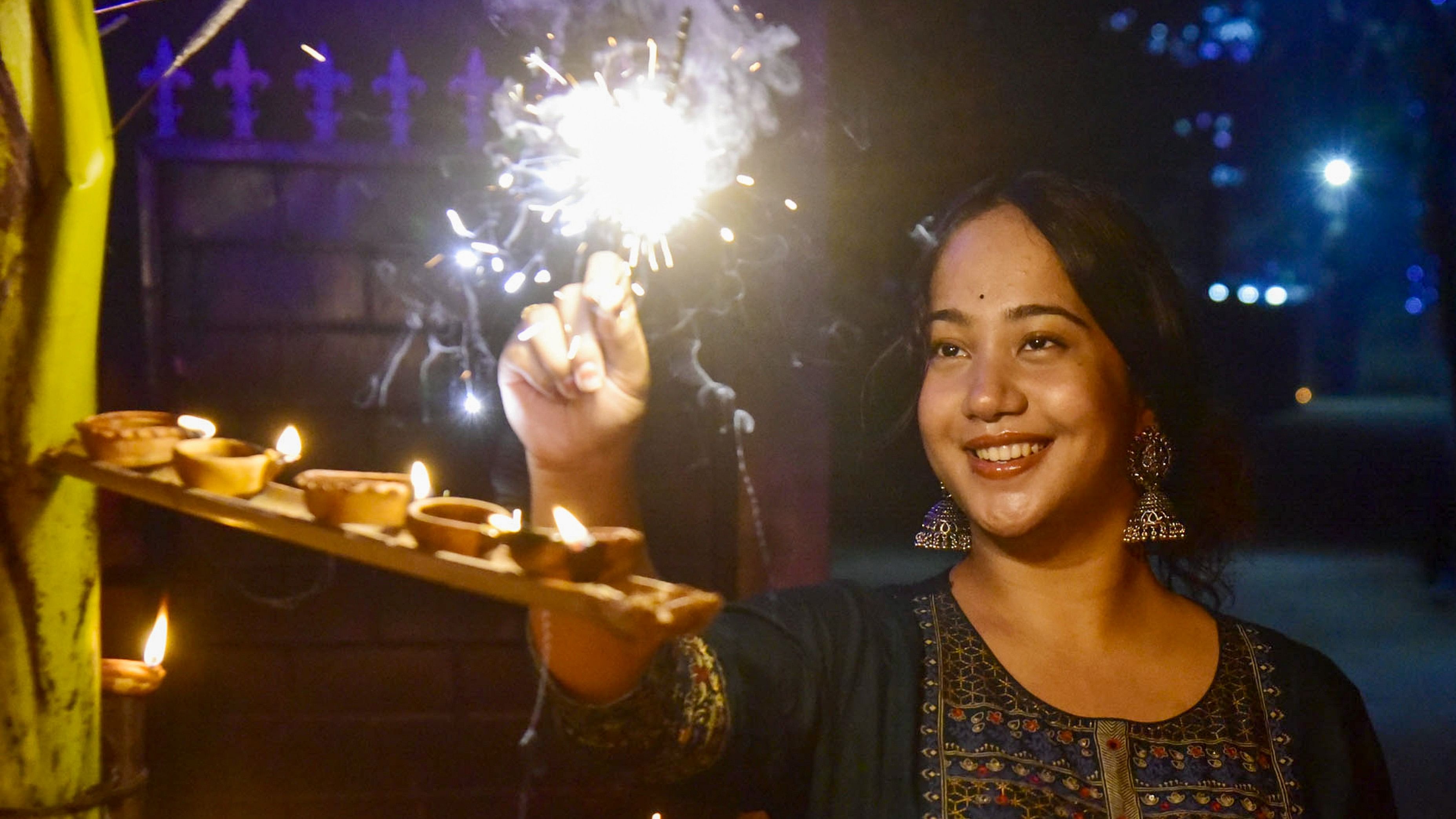 <div class="paragraphs"><p>A young woman burns sparkle to celebrate Diwali.&nbsp;</p></div>