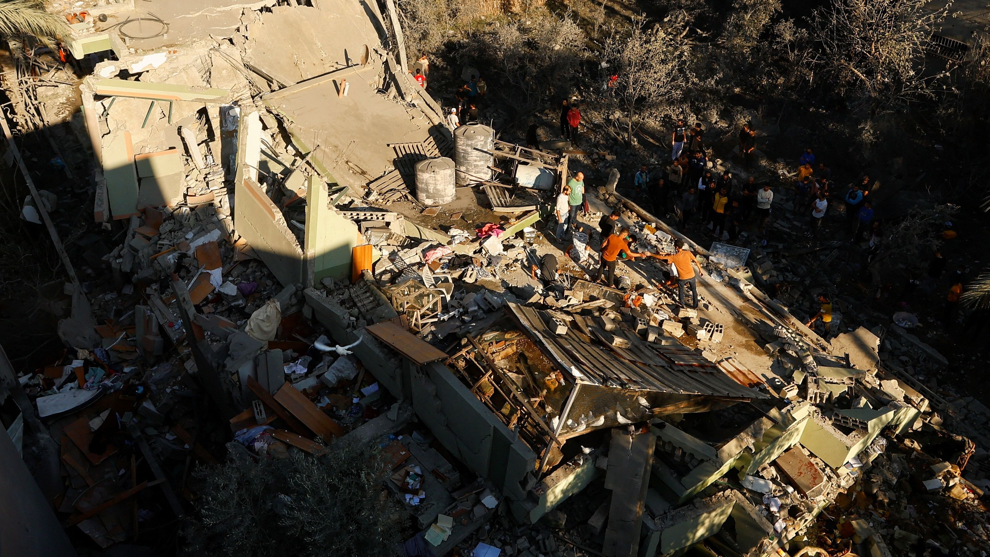 <div class="paragraphs"><p>Palestinians stand at the site of an Israeli strike on a house, amid the ongoing conflict between Israel and Palestinian Islamist group Hamas, in Khan Younis in the southern Gaza Strip.&nbsp;</p></div>