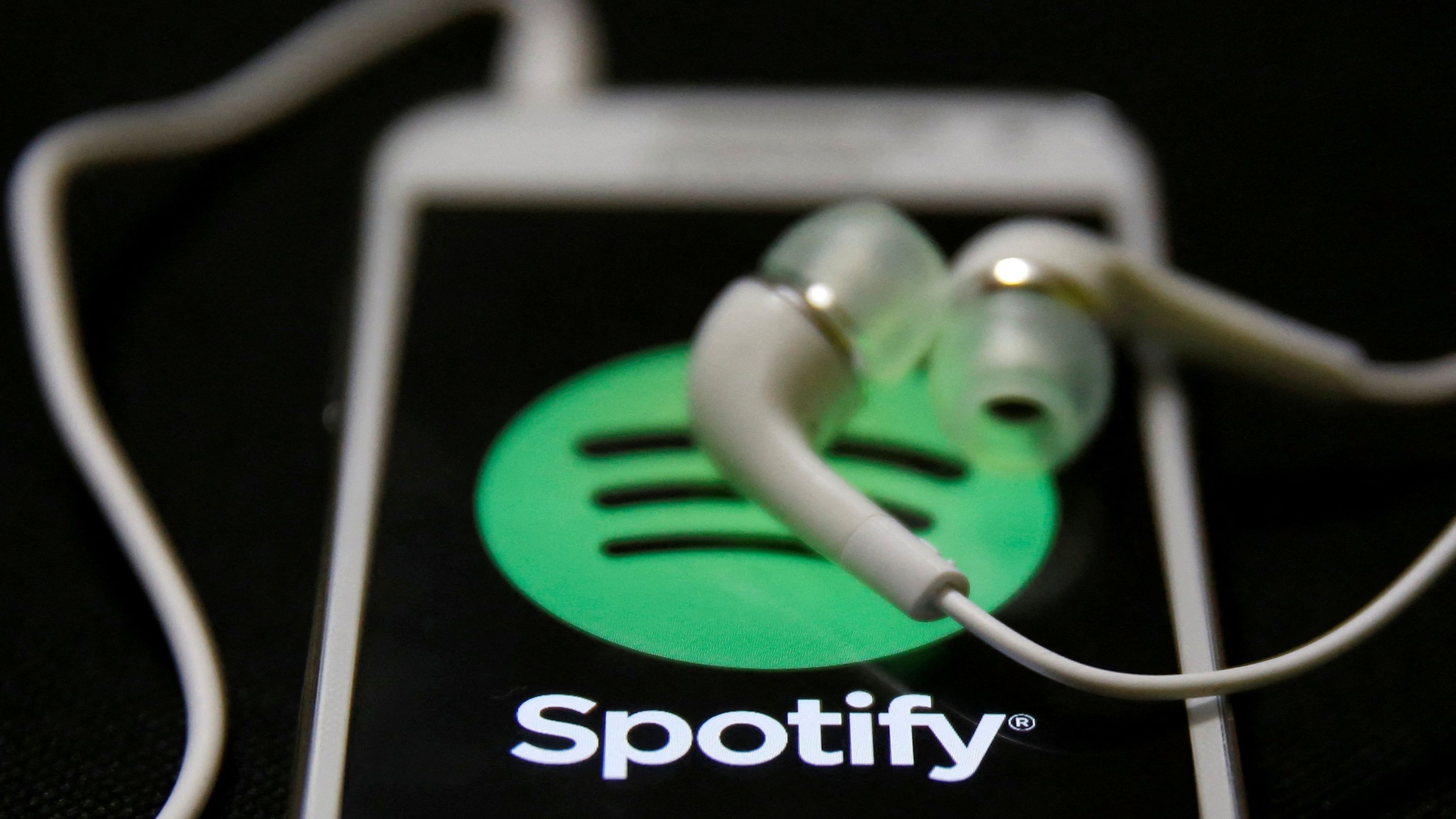 <div class="paragraphs"><p>Earphones are seen on top of a smart phone with a Spotify logo on it.&nbsp;</p></div>