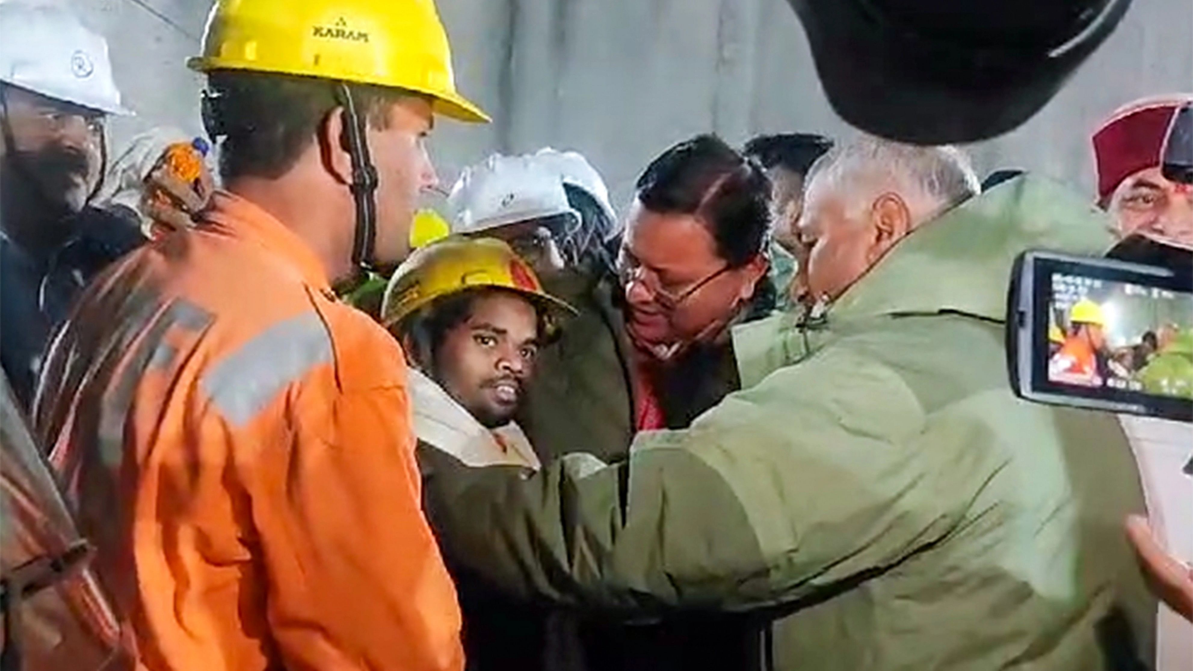 <div class="paragraphs"><p>Uttarakhand Chief Minister Pushkar Singh Dhami and Union Minister of State for Road Transport &amp; Highways VK Singh greet a worker after his evacuation from the collapsed Silkyara Tunnel, in Uttarkashi district, Tuesday, Nov. 28, 2023.   </p></div>