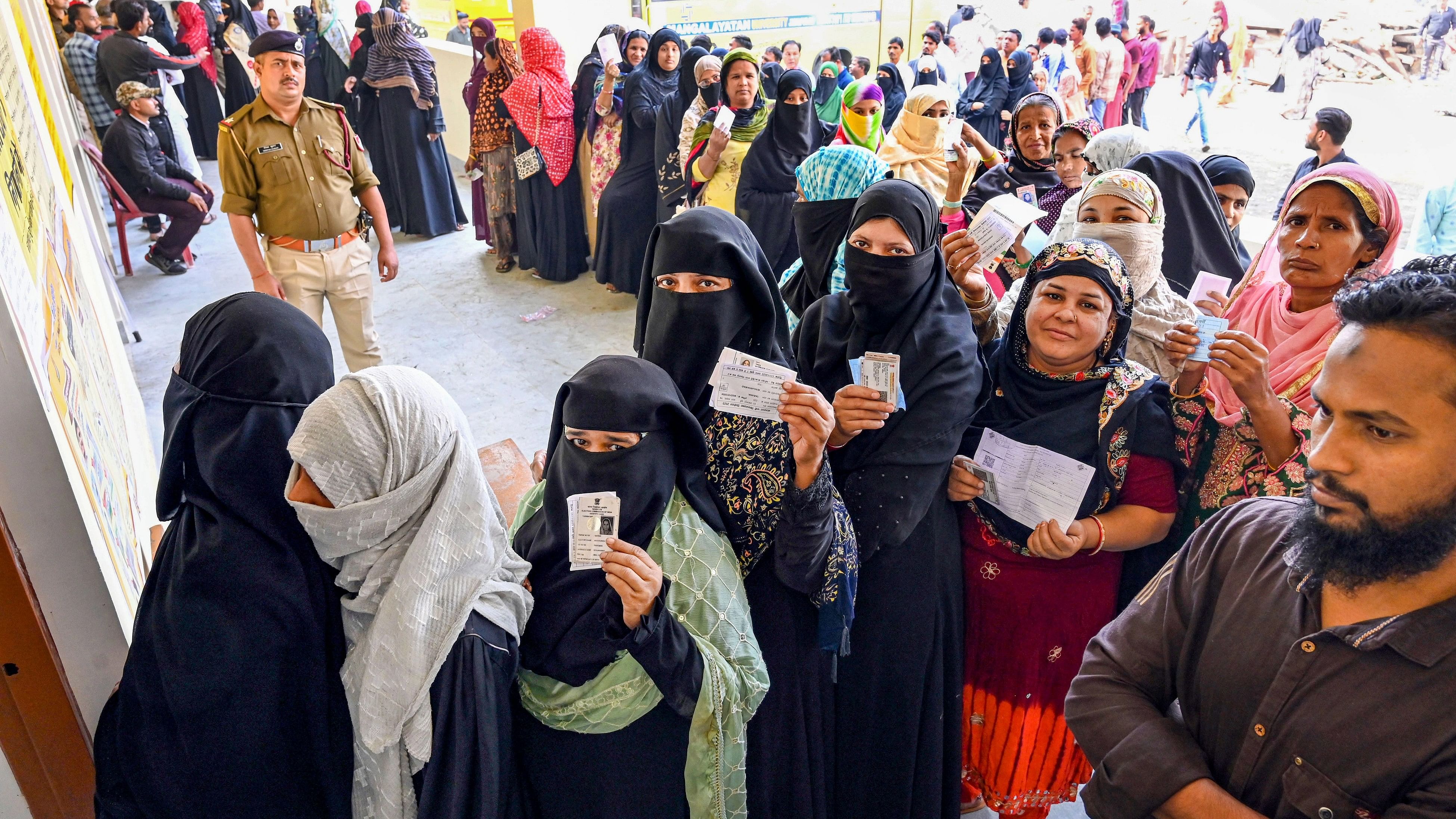 <div class="paragraphs"><p>Voters show their identification cards as they wait in queues at a polling station to cast their votes for the Madhya Pradesh Assembly elections, in Jabalpur, Friday, Nov. 17, 2023. </p></div>