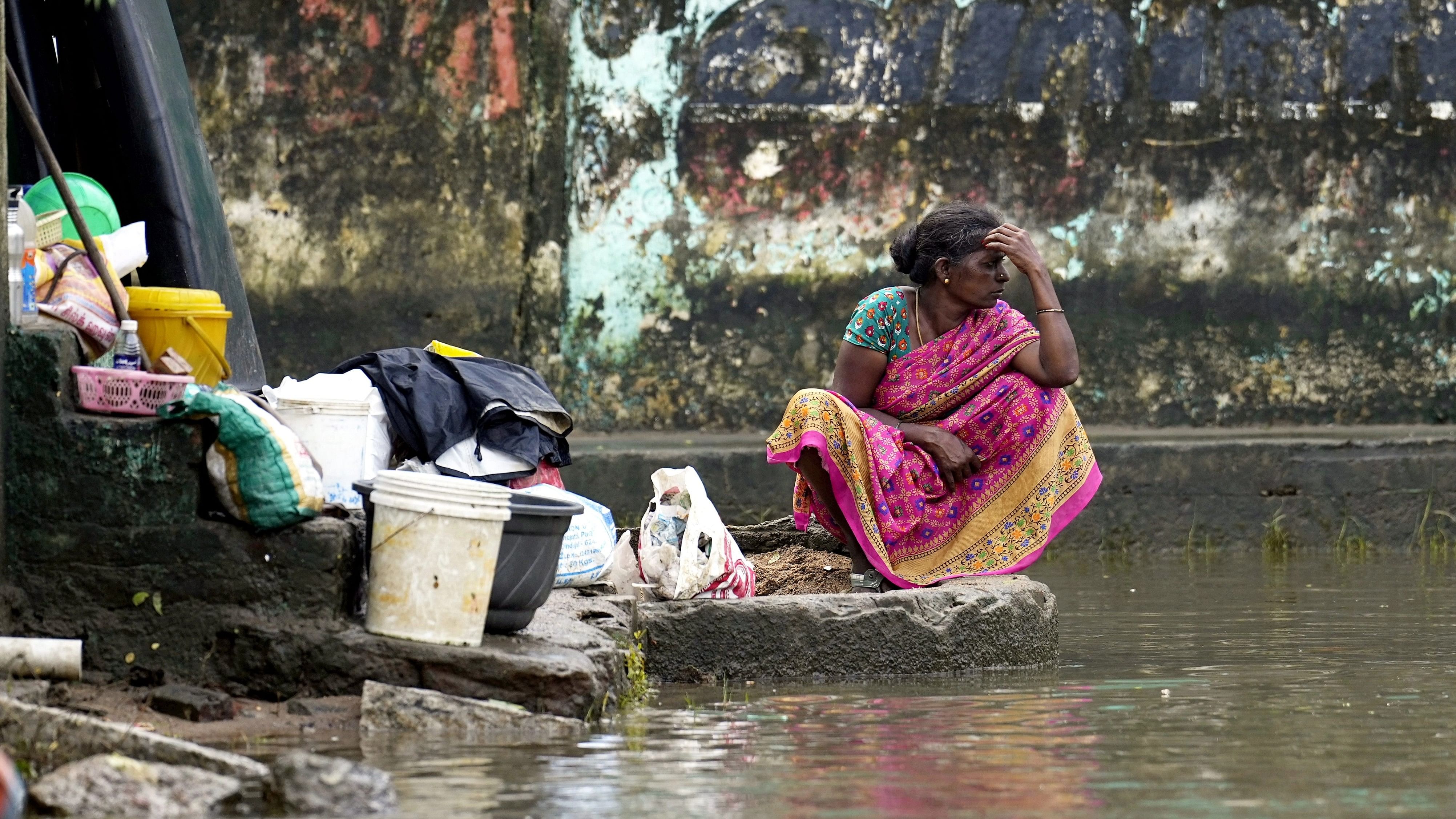 <div class="paragraphs"><p>A woman retrieves her belongings at Kamatchi Amman Nagar area inundated with floodwater after heavy rainfall in the aftermath of Cyclone Michaung, in Chennai.</p></div>