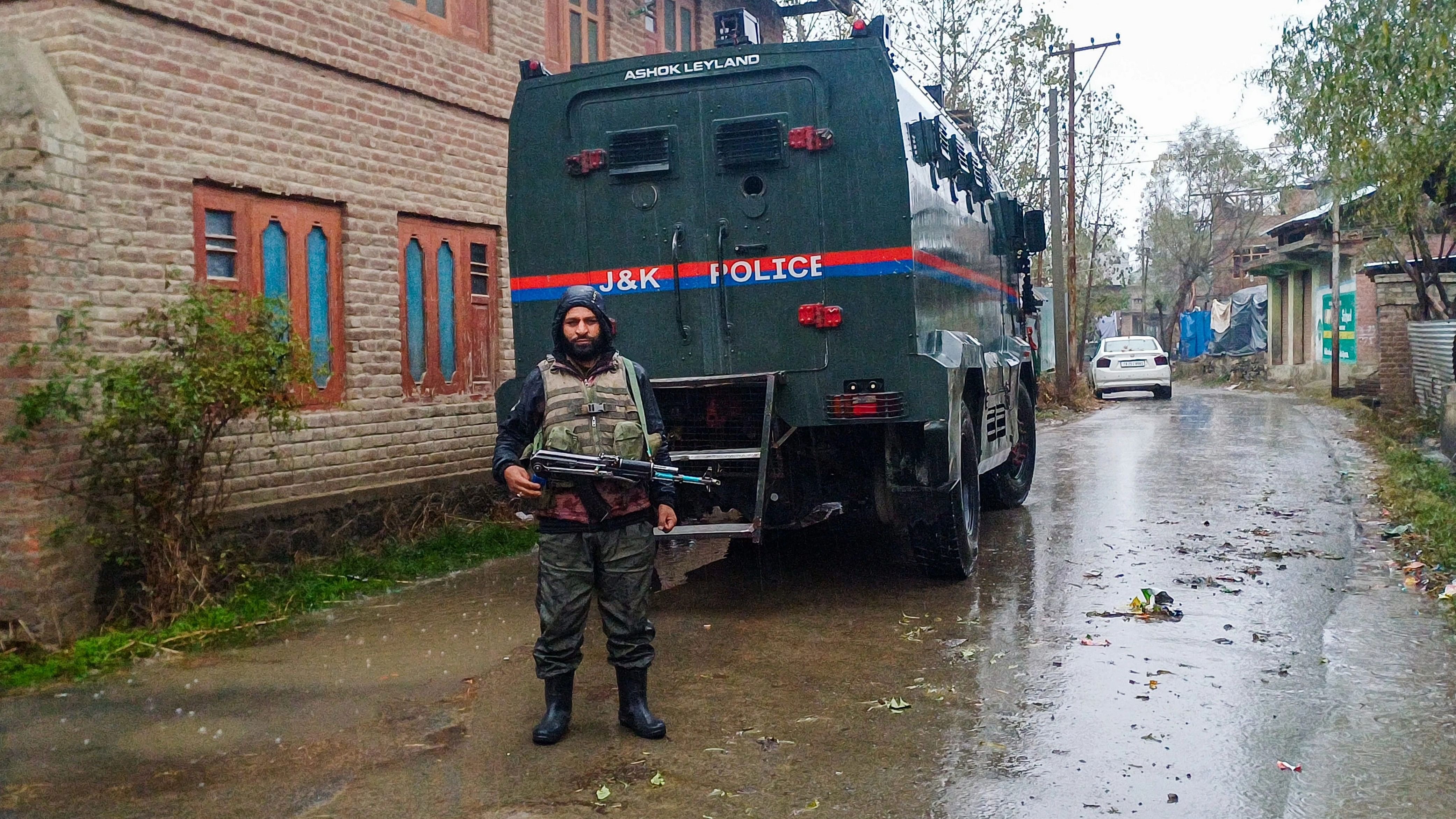 <div class="paragraphs"><p>A security personnel stands guard during a raid by J&amp;K Police's State Investigation Agency (SIA) in connection with a terror funding case, in Anantnag district, on November 10, 2023. </p></div>