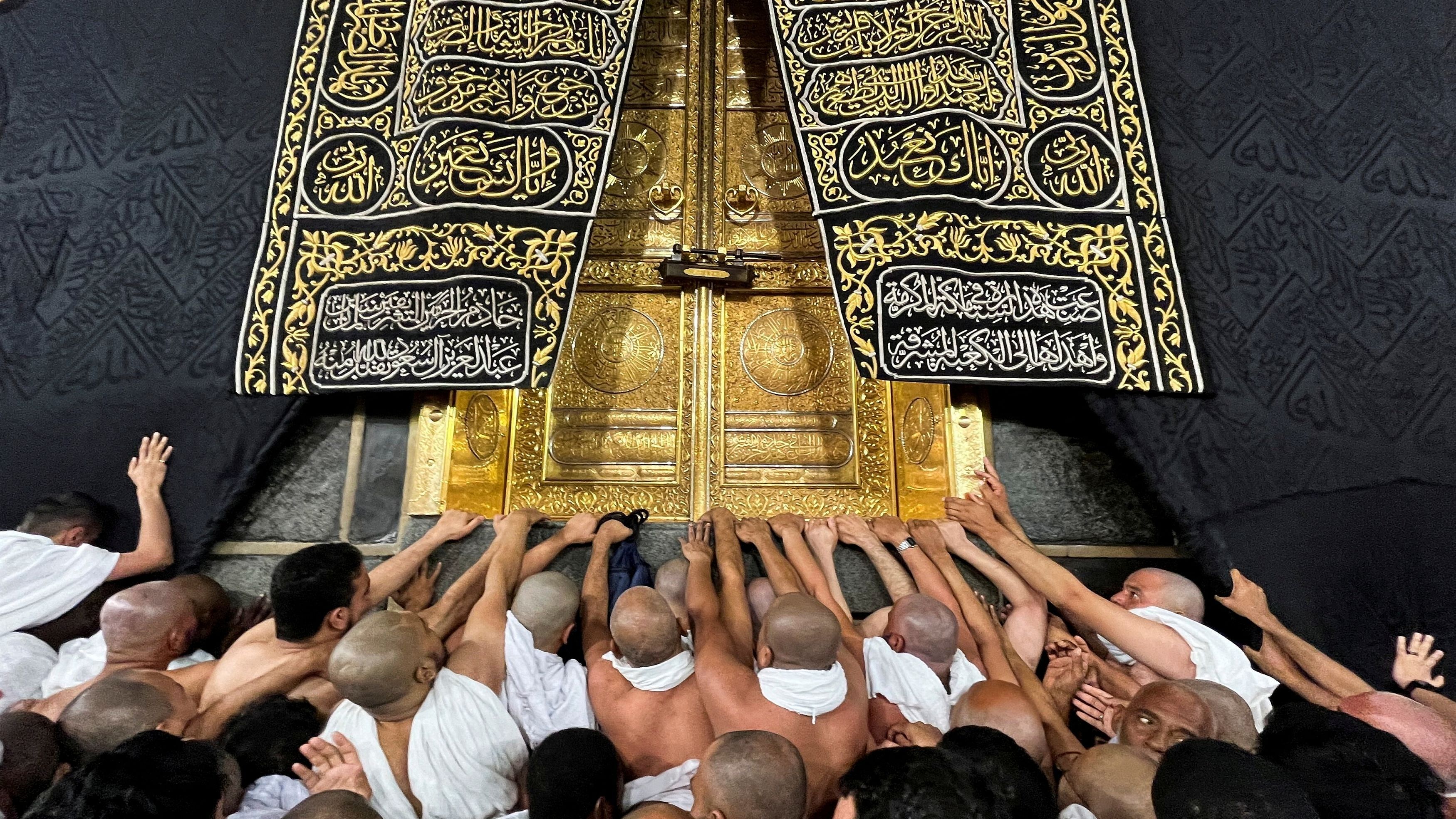 <div class="paragraphs"><p>Muslims touch and pray at the door of the Kaaba during their Umrah, at the Grand Mosque, in the holy city of Mecca, Saudi Arabia, December 18, 2023. </p></div>