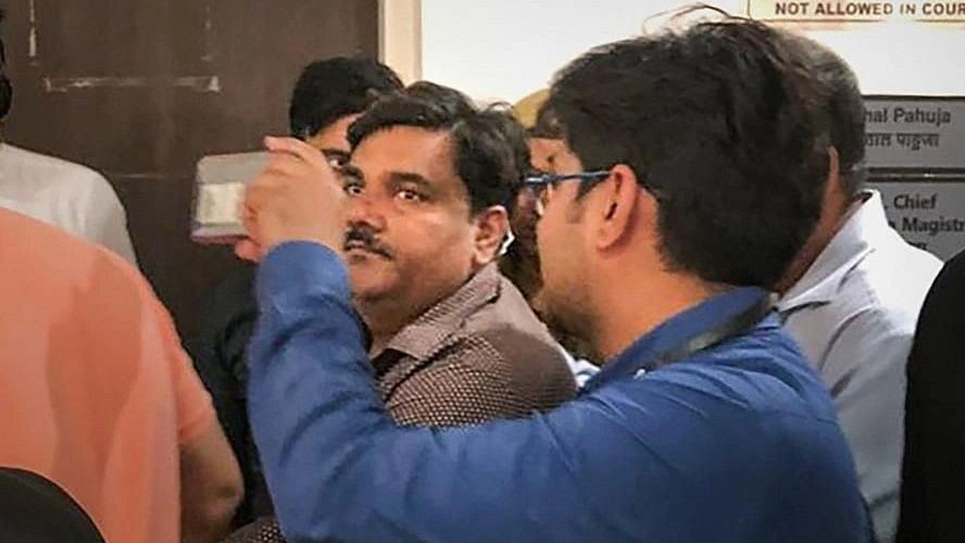 <div class="paragraphs"><p>Delhi police personnel take suspended AAP councillor Tahir Hussain into custody after Delhi Court rejected his plea to surrender before it, at Rouse Avenue Court in New Delhi, Thursday, March 5, 2020.</p></div>