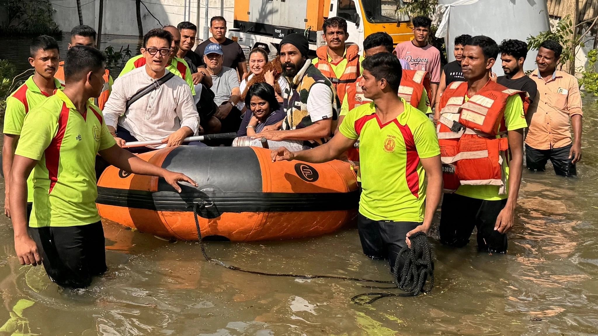 <div class="paragraphs"><p>Aamir Khan is seen with the rescue officials after being evacuated.&nbsp;</p></div>