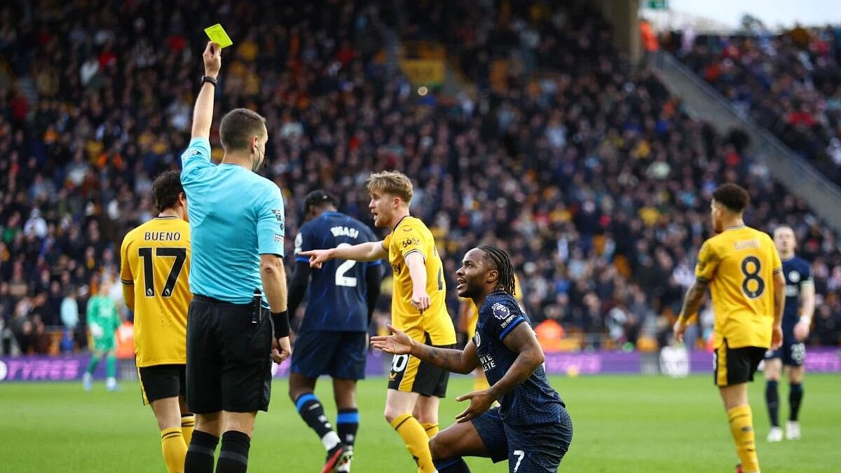 <div class="paragraphs"><p>Chelsea's Raheem Sterling is shown a yellow card by referee David Coote after committing a simulation.</p></div>