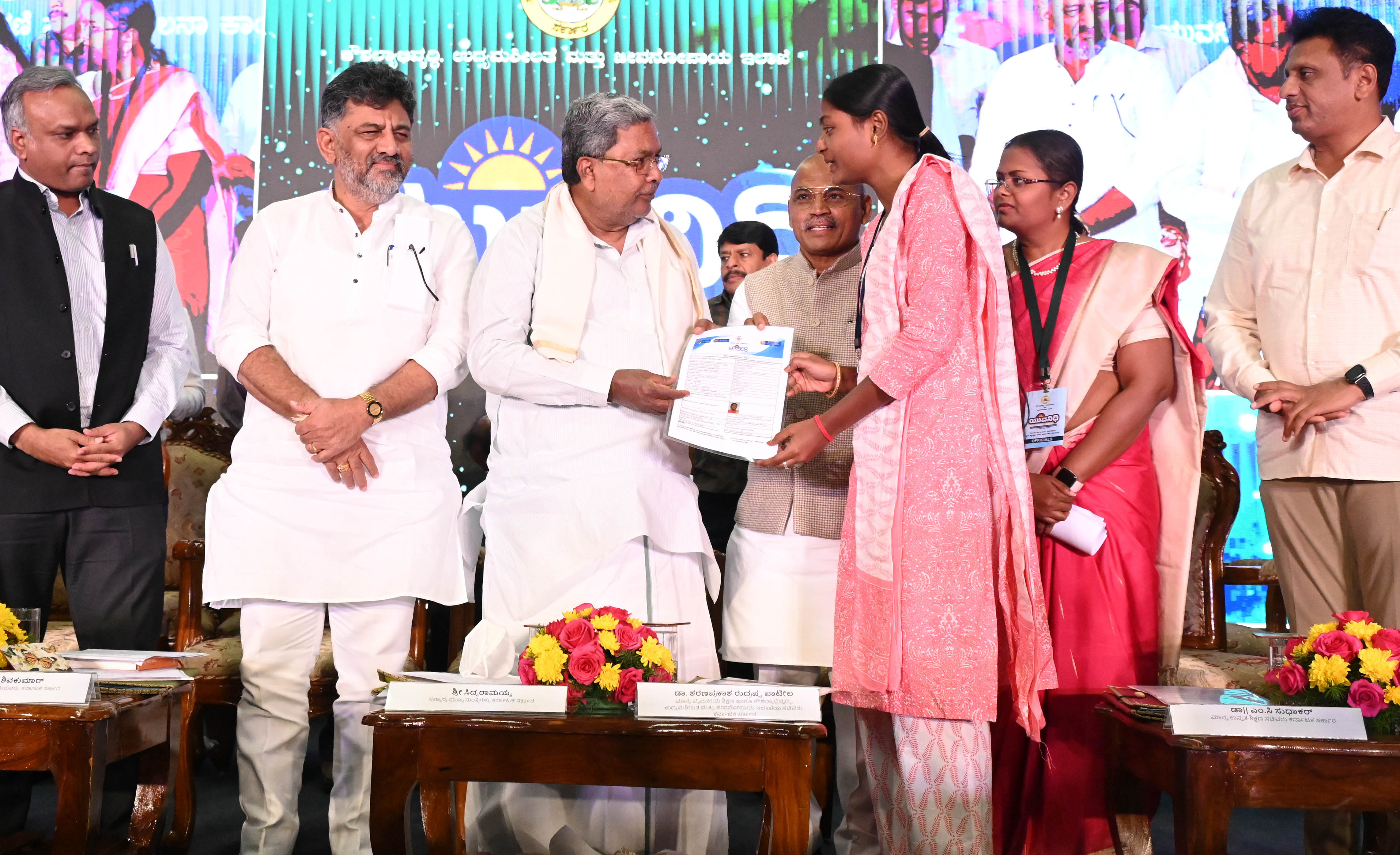 <div class="paragraphs"><p>Chief Minister Siddaramaiah hands over an acknowledgement of 'Yuva Nidhi' scheme to an unemployed girl at the launch of Congress' 5th guarantee at Vidhana Soudha in Bengaluru on Tuesday. Minister Priyank Kharge, Deputy CM D K Shivakumar, Ministers Dr Sharan Prakash Patil and Dr M C Sudhakar are seen. </p></div>