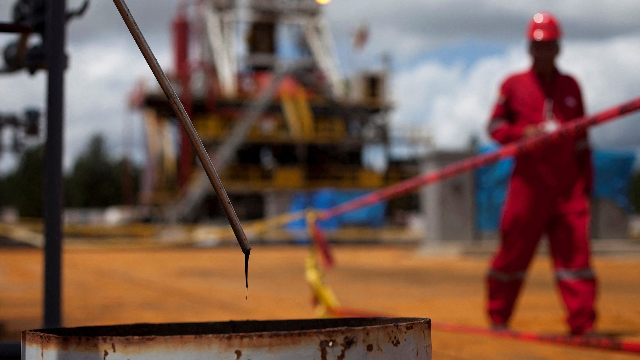 <div class="paragraphs"><p> Crude oil drips from a valve as a worker walks past at an oil well operated by Venezuela's state oil company.</p></div>