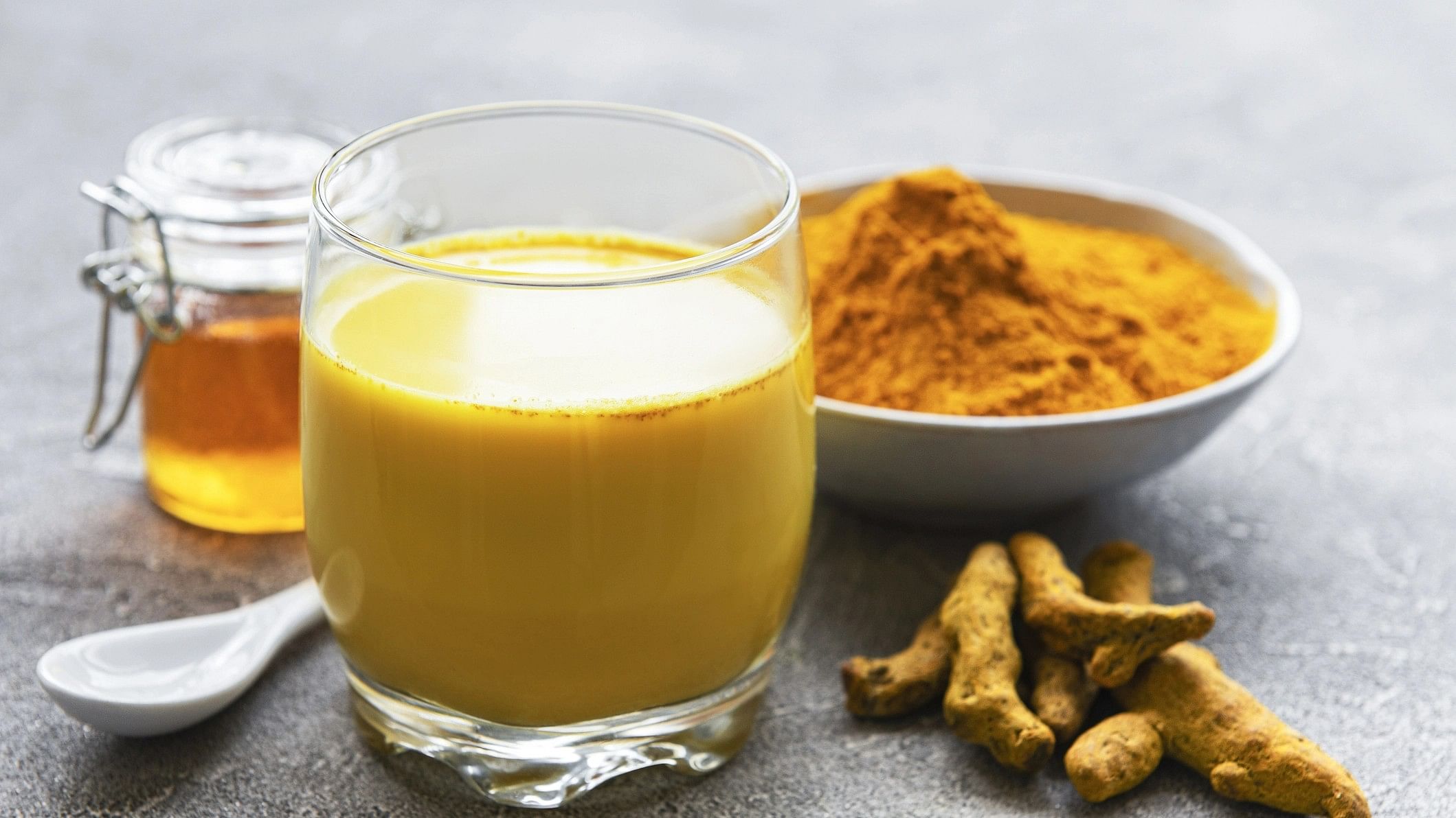 <div class="paragraphs"><p>Turmeric latte drink. Golden milk with cinnamon, turmeric, ginger and honey over grey concrete background.</p></div>