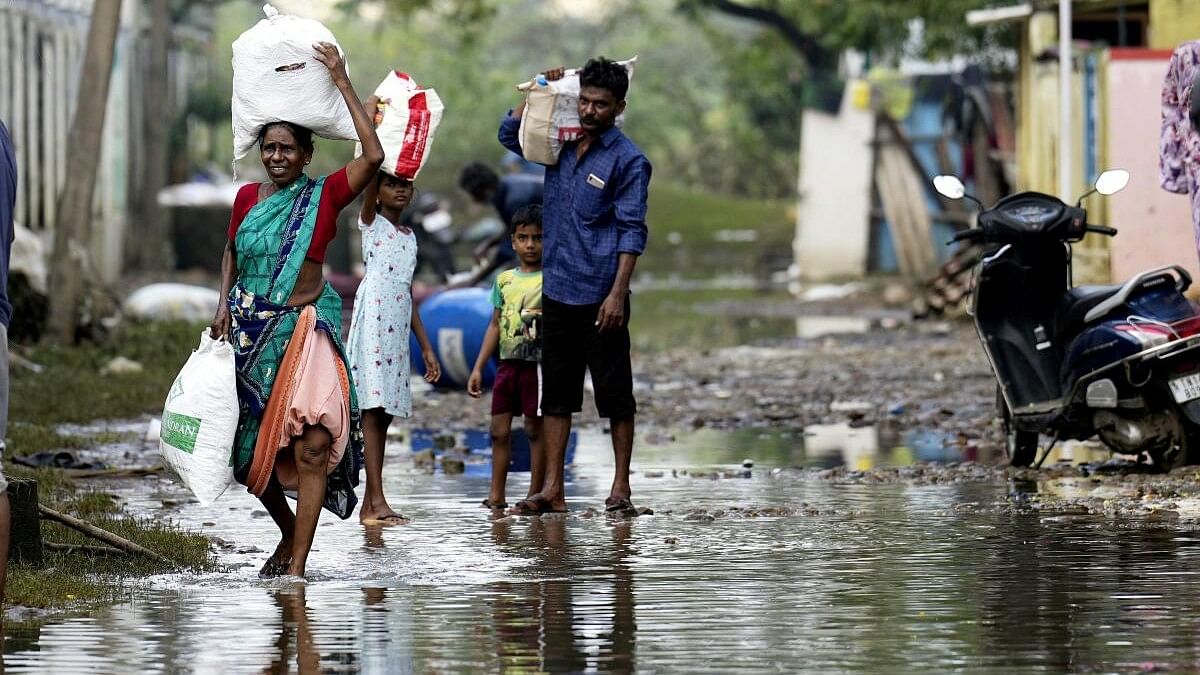<div class="paragraphs"><p>Locals retrieve their belongings at Kamatchi Amman Nagar area inundated with floodwater after heavy rainfall in the aftermath of Cyclone Michaung, in Chennai.</p></div>