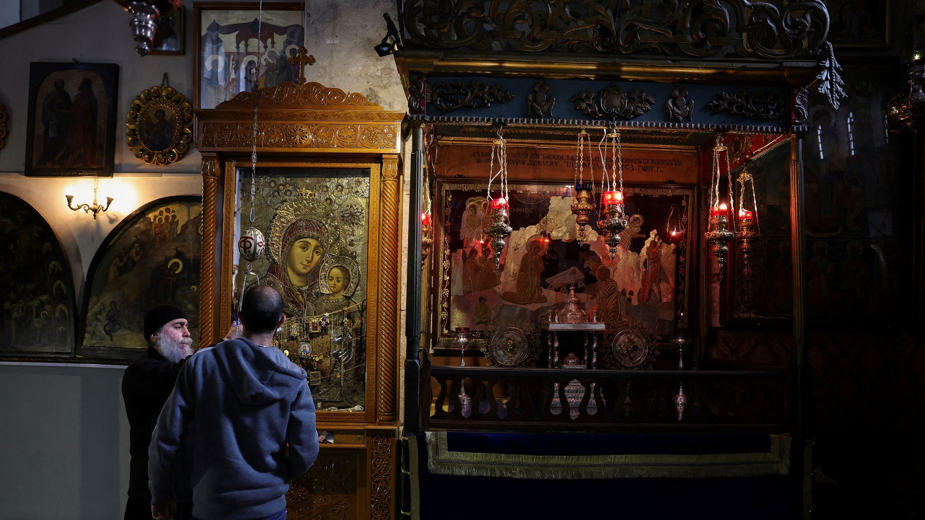 <div class="paragraphs"><p>Members of clergy change oil in a lamp in the Church of the Nativity, in Bethlehem in the Israeli-occupied West Bank December 23,2023.</p></div>