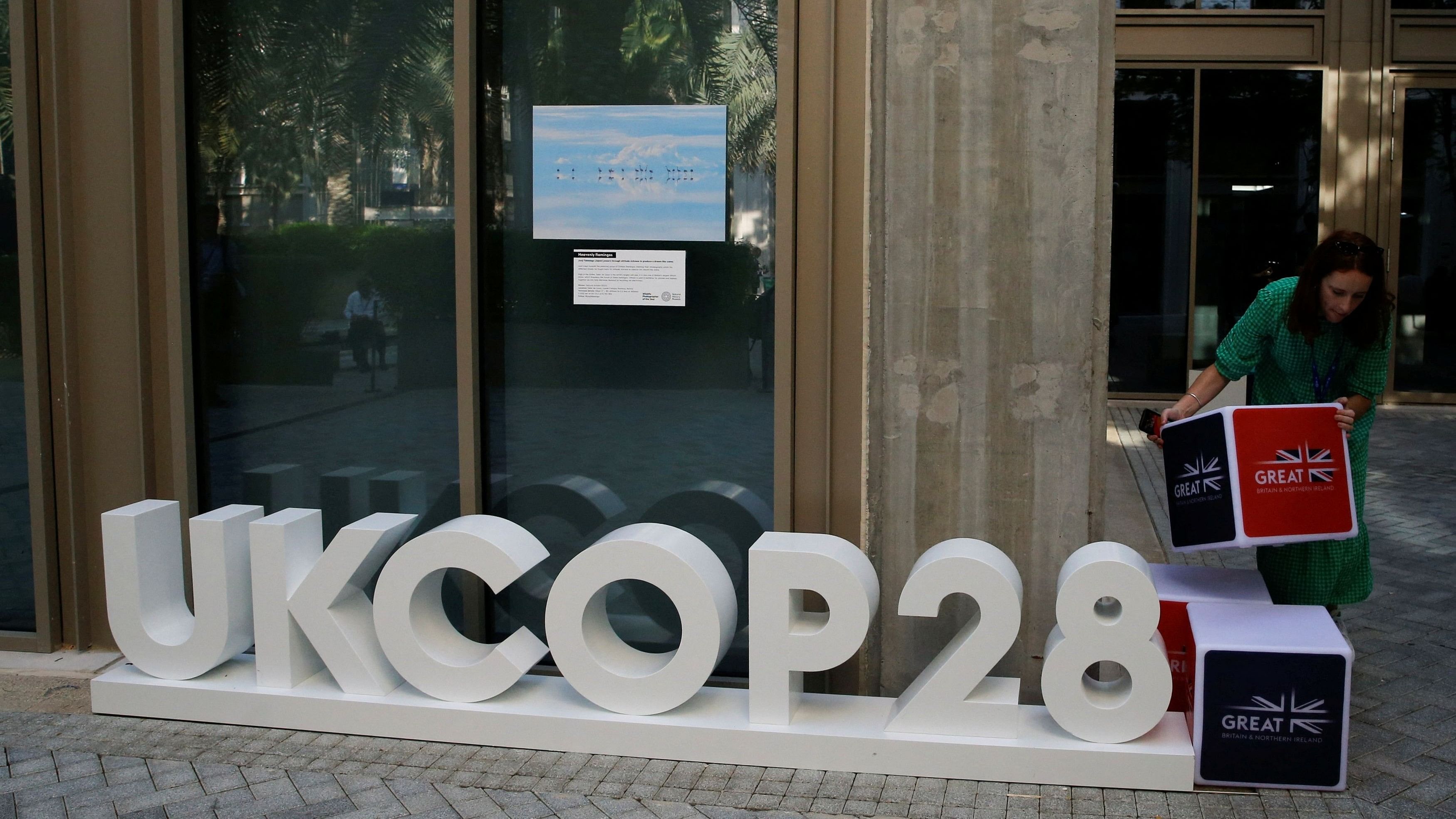 <div class="paragraphs"><p>A delegate arranges a display outside the United Kingdom pavilion at the Dubai's Expo City, during the United Nations Climate Change Conference  in Dubai, United Arab Emirates, December 4, 2023. </p></div>