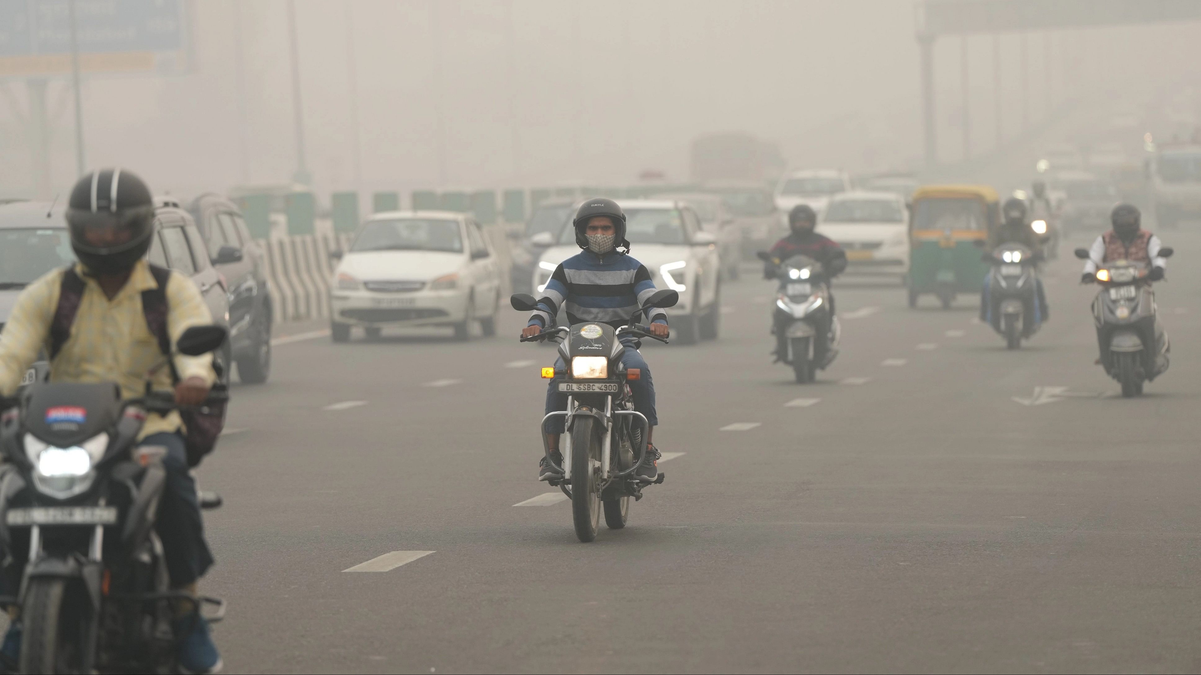 <div class="paragraphs"><p>Commuters on a road shrouded in smog amid hazy weather conditions, in New Delhi</p></div>