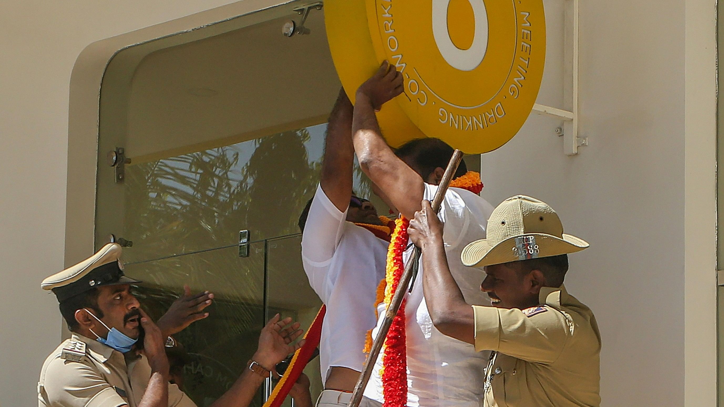 <div class="paragraphs"><p>Police personnel try to stop Karnataka Rakshana Vedike (Narayana Gowda faction) activists vandalising a signboard of a business establishment, in Bengaluru, Wednesday, Dec. 27, 2023. </p></div>