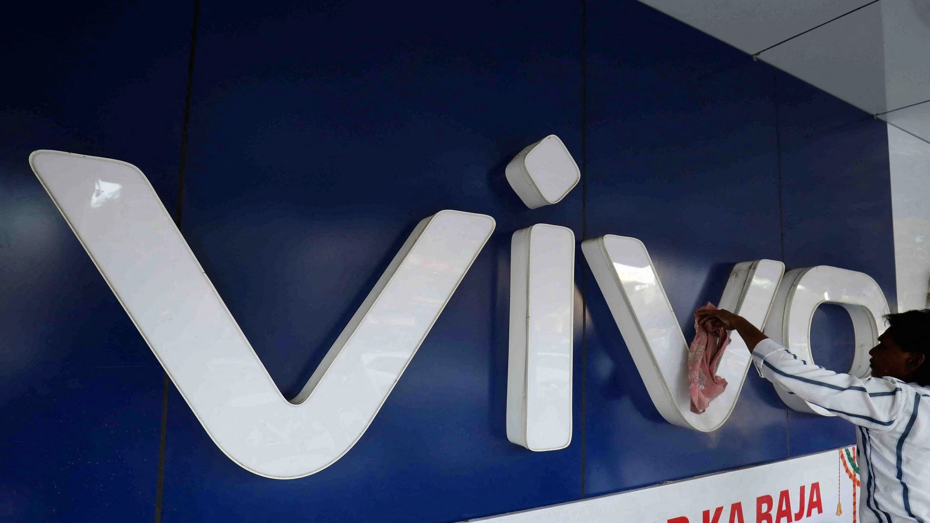 <div class="paragraphs"><p>A man cleans the logo of a Chinese smartphone brand Vivo outside a store in Ahmedabad.&nbsp;</p></div><div class="paragraphs"><p><strong><br></strong></p></div>