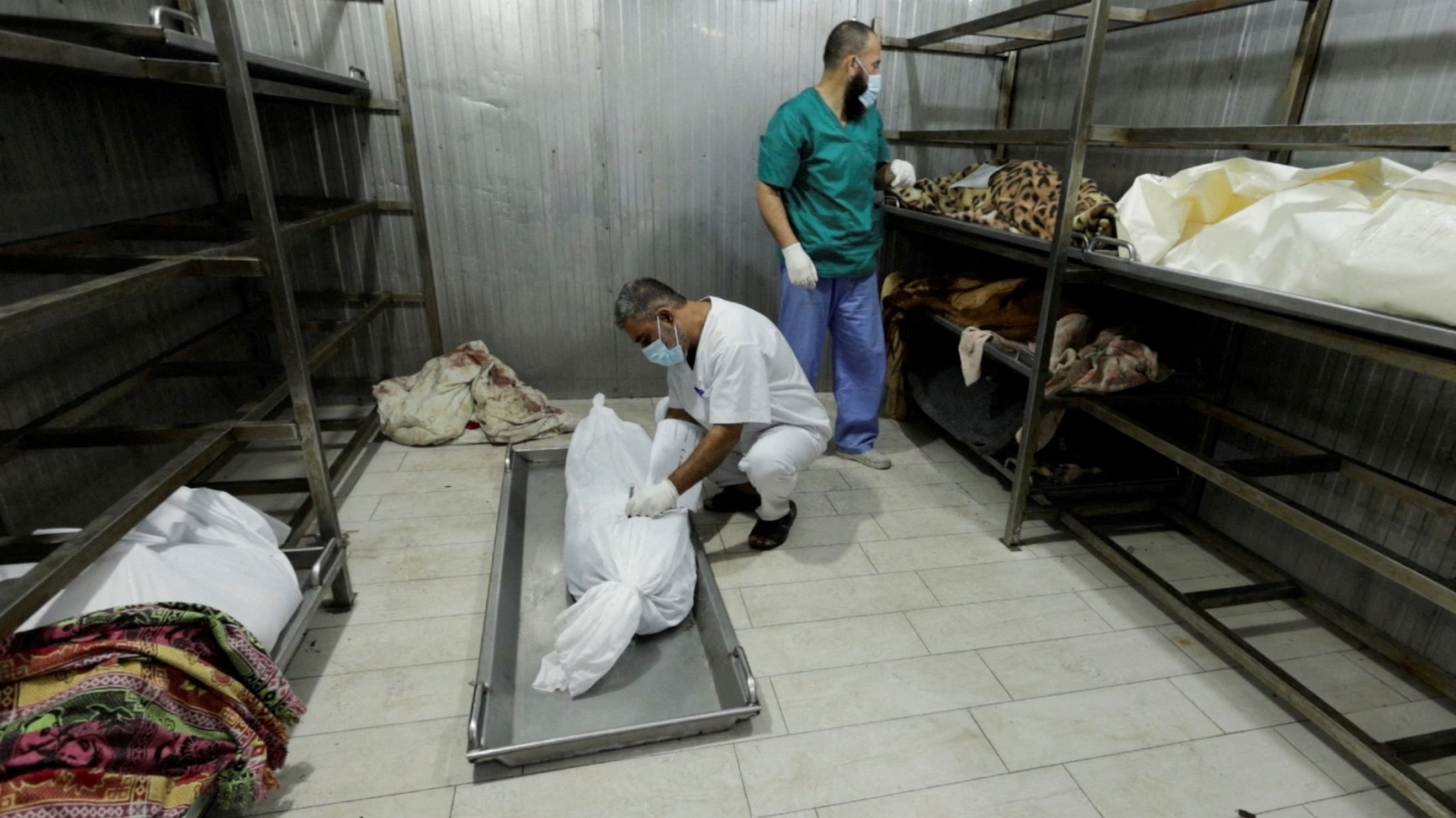 <div class="paragraphs"><p>Supervisor of Nasser hospital's morgue, writes a name on the body of a Palestinian who was killed in an Israeli strike in Khan Younis in the southern Gaza Strip.</p></div>