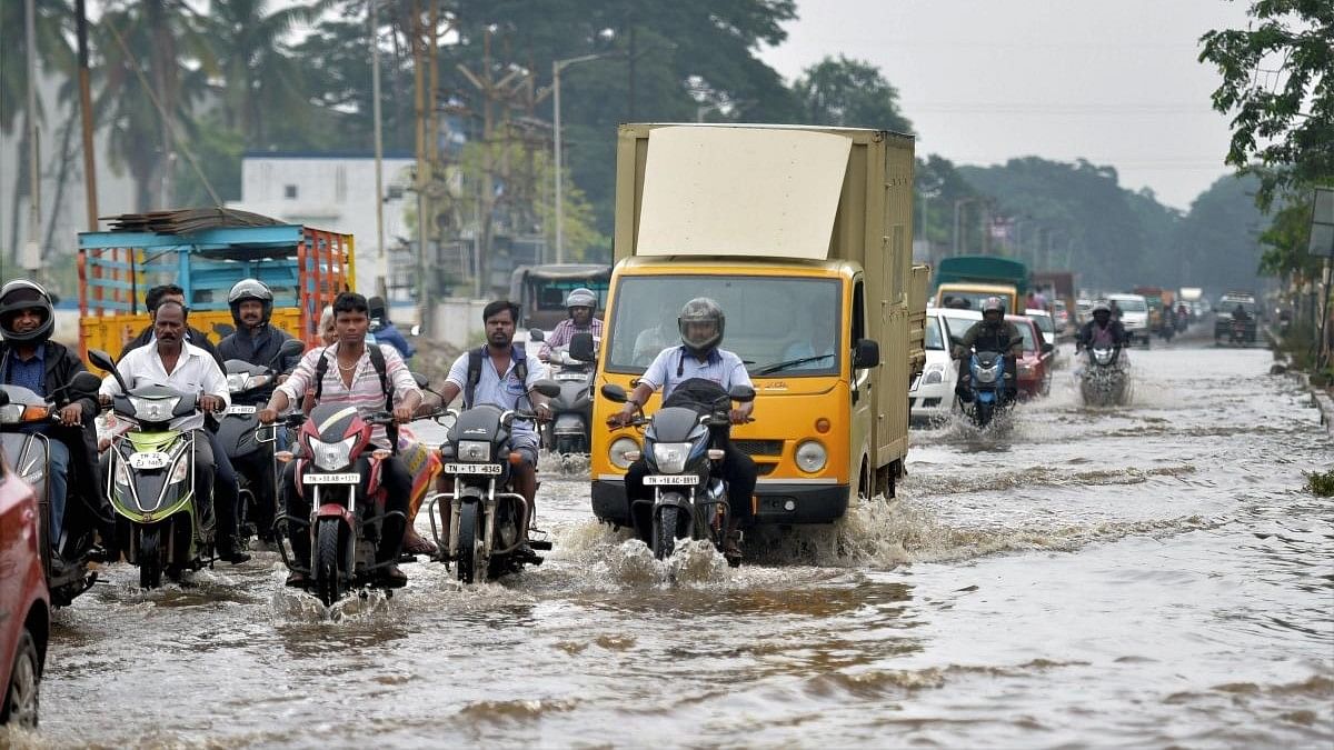 <div class="paragraphs"><p>People move through a flooded road in Chennai.</p></div>