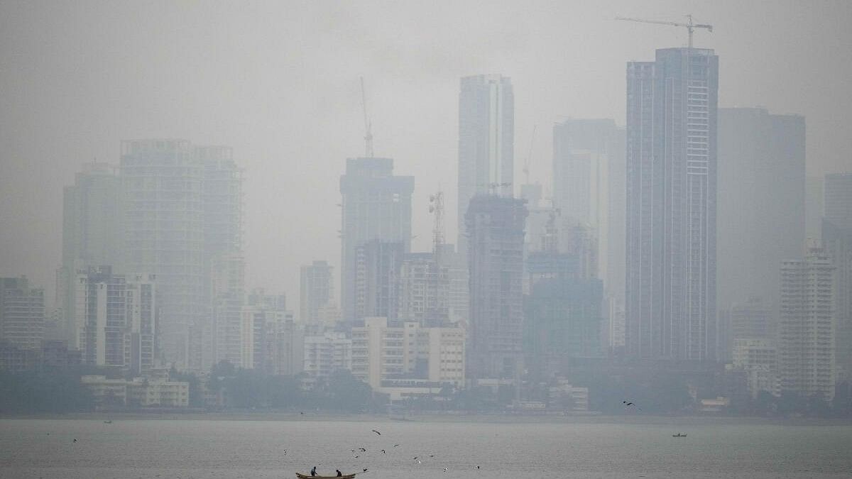 <div class="paragraphs"><p>Fishermen row their boat as smog engulfs the city skyline, in Mumbai.</p></div>