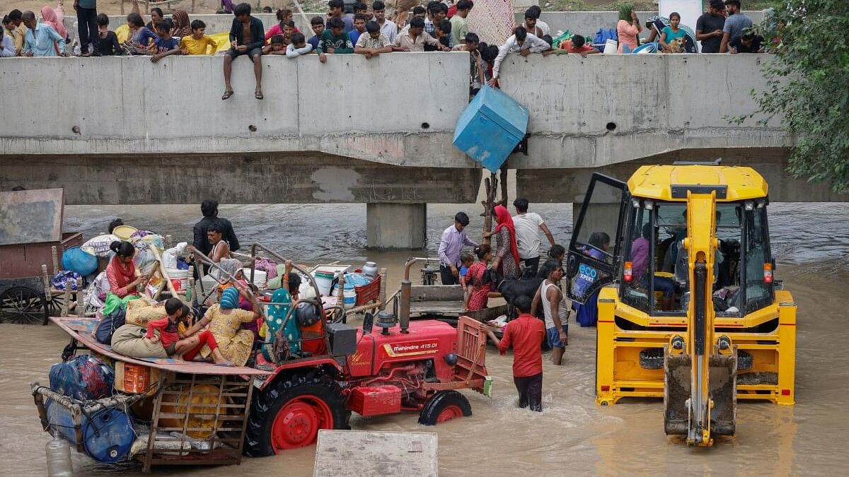 <div class="paragraphs"><p>Residents climb on to a flyover under construction after being displaced by the rising water level of river Yamuna after heavy monsoon rains in New Delhi.</p></div>