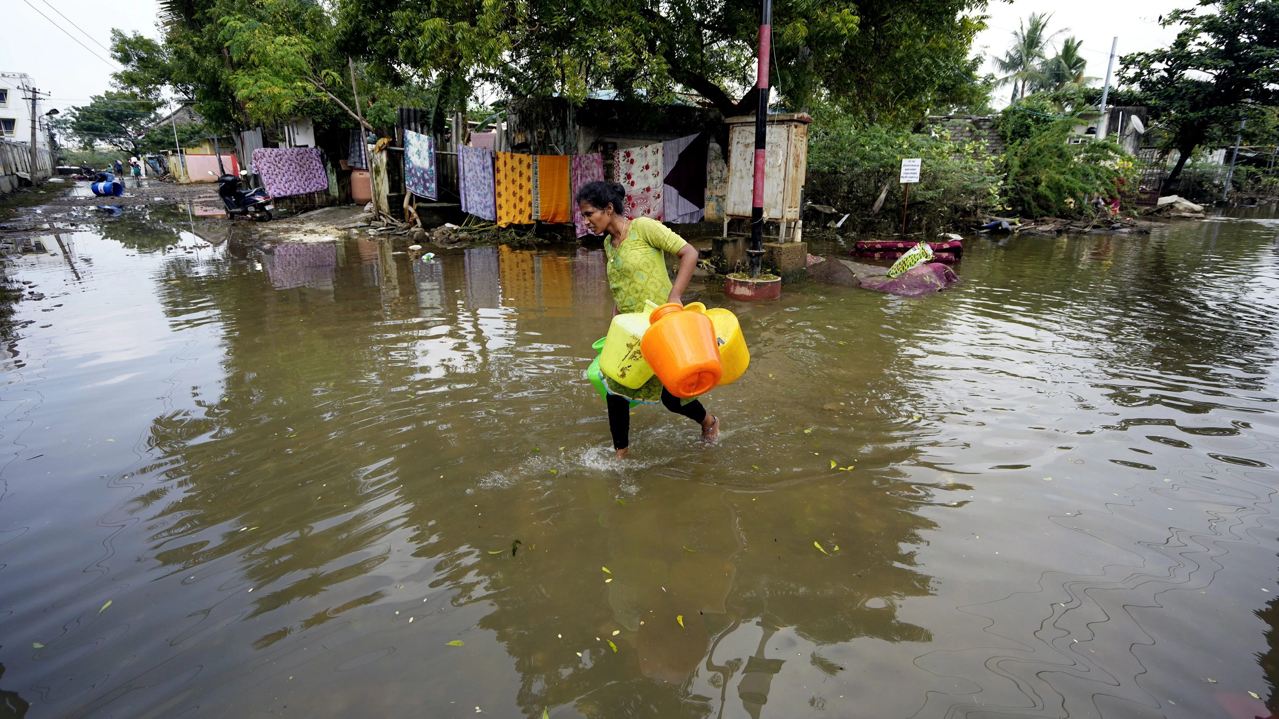 <div class="paragraphs"><p>A woman wades through floodwater at Kamatchi Amman Nagar area in Chennai in the aftermath of Cyclone Michaung.</p></div>