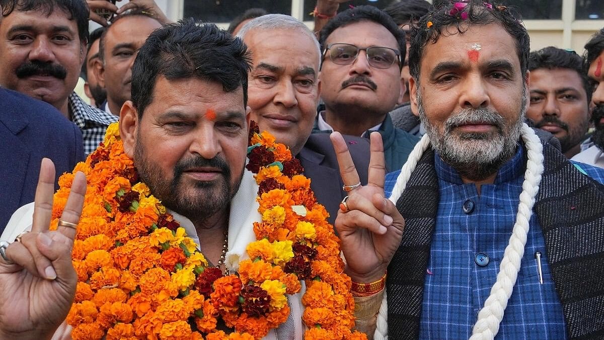 <div class="paragraphs"><p>Sanjay Singh (right) with&nbsp;BJP MP Brij Bhushan Sharan Singh.</p></div>