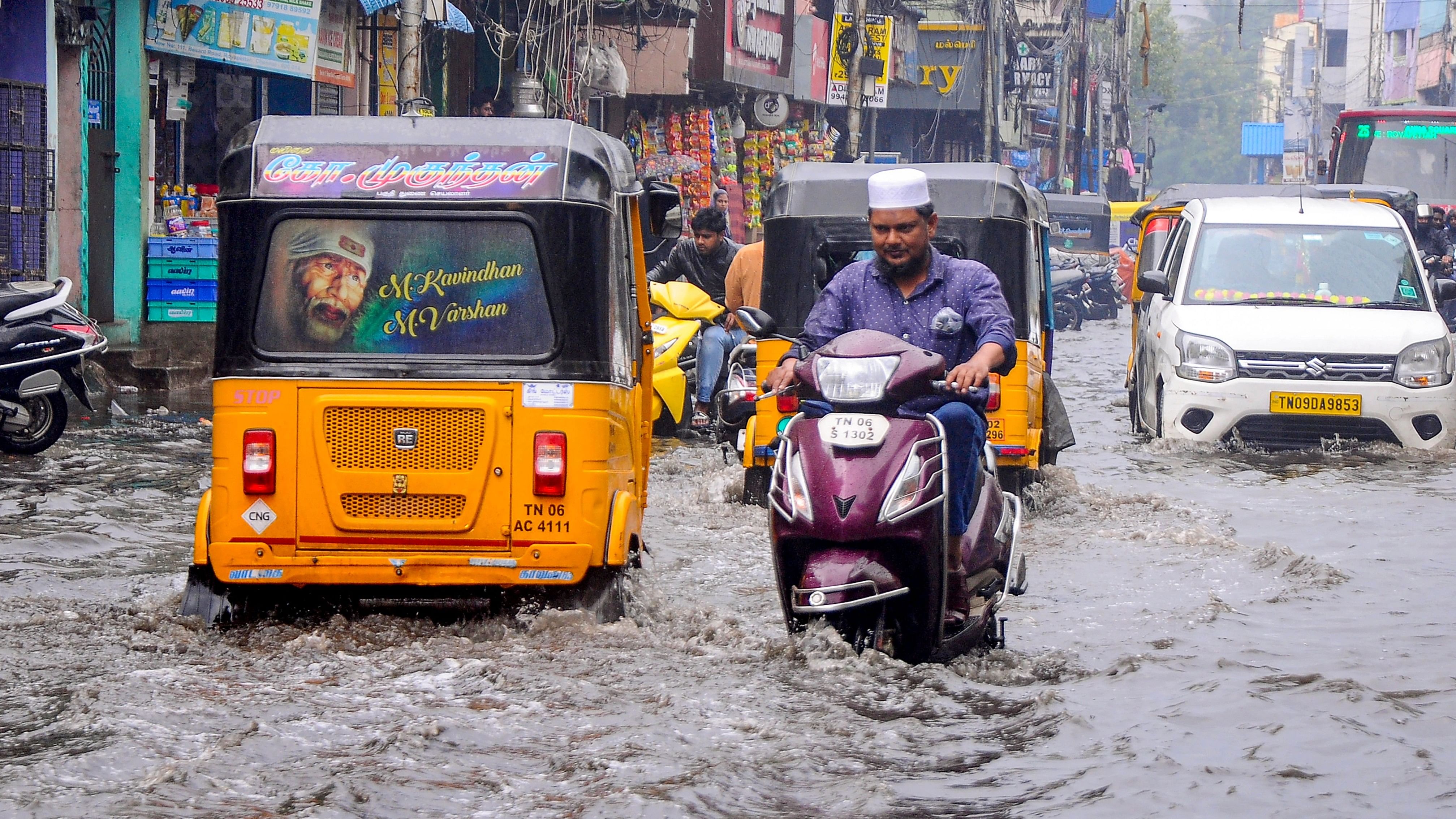 <div class="paragraphs"><p>Commuters make their way amid rains on a waterlogged road, at Marina Beach in Chennai, Tamil Nadu, Tuesday, Nov. 14, 2023. </p></div>