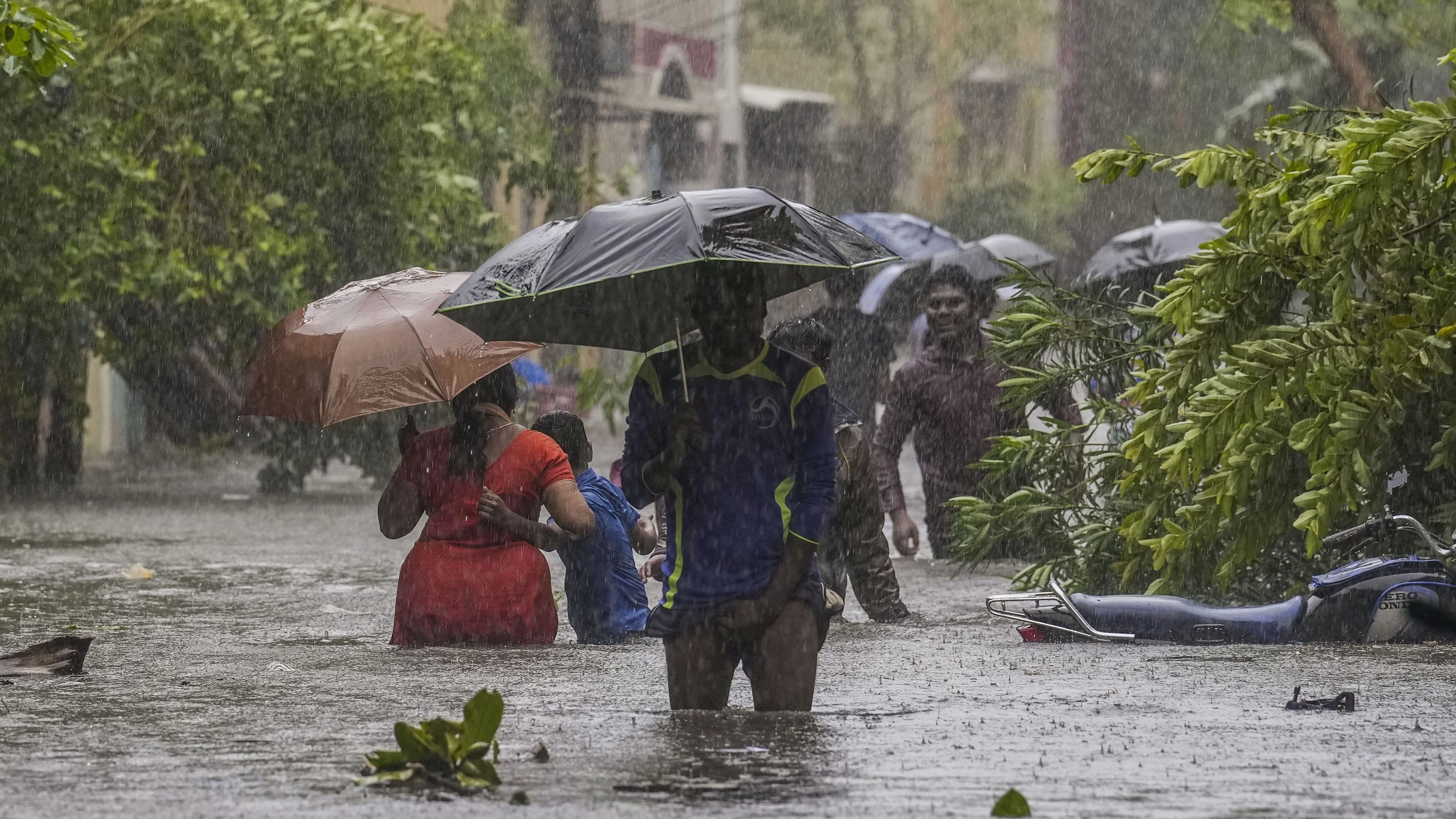 <div class="paragraphs"><p>People wade through a waterlogged road during heavy rain owing to Cyclone Michaung in Chennai on Monday, December 4, 2023. </p></div>