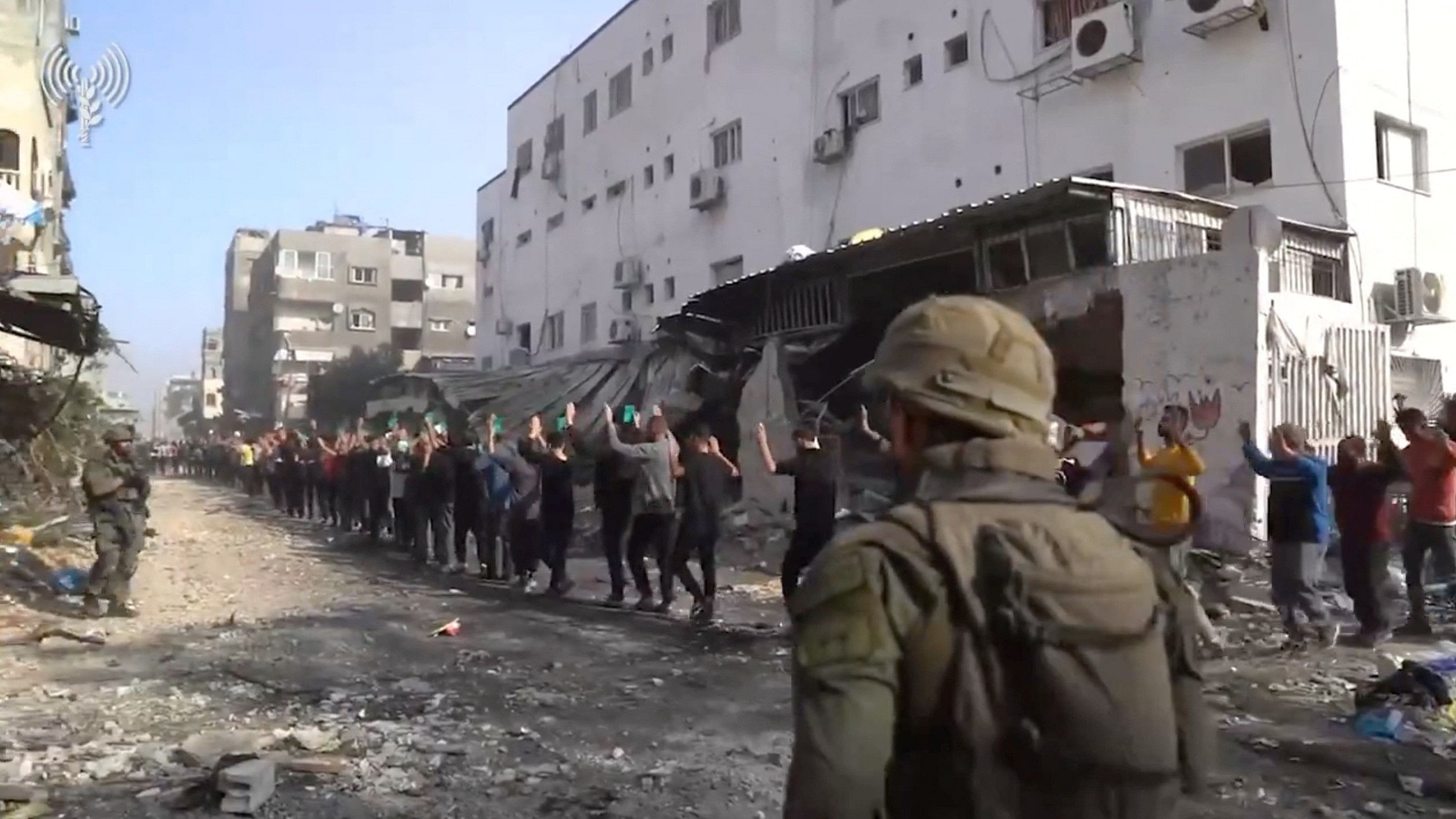 <div class="paragraphs"><p>Israeli soldiers stand guard as men with raised hands are led out near Kamal Adwan hospital, amid the ongoing conflict between Israel and the Palestinian Islamist group Hamas, in Jabalia in the northern Gaza Strip, in this screen grab from a handout video released December 14, 2023.</p></div>