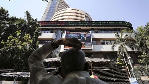 <div class="paragraphs"><p>A man looks at a screen across the road displaying the Sensex on the facade of the BSE building in Mumbai.</p></div>