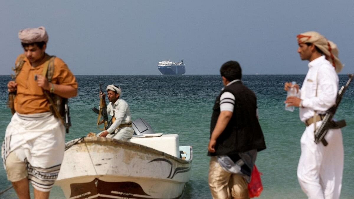 <div class="paragraphs"><p>Armed men stand on the beach as the Galaxy Leader commercial ship, seized by Yemen's Houthis last month, is anchored off the coast of al-Salif, Yemen, December 5, 2023.</p></div>