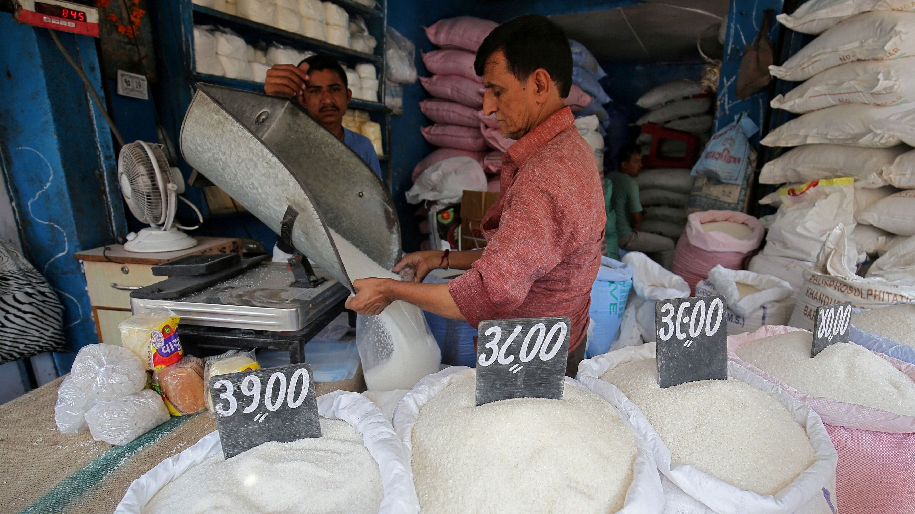 <div class="paragraphs"><p>A man packs sugar for sale inside a shop at a marketplace in Ahmedabad.&nbsp;</p></div>