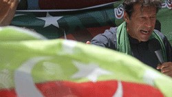 <div class="paragraphs"><p>Imran Khan behind&nbsp;Pakistan Tehreek-e-Insaaf (PTI) party flag.</p></div>