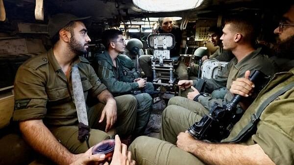 <div class="paragraphs"><p>Israeli soldiers sit inside a military vehicle on the Israeli side of the border with Gaza, amid the ongoing conflict between Israel and the Palestinian Islamist group Hamas, in Southern Israel, December 18, 2023.</p></div>