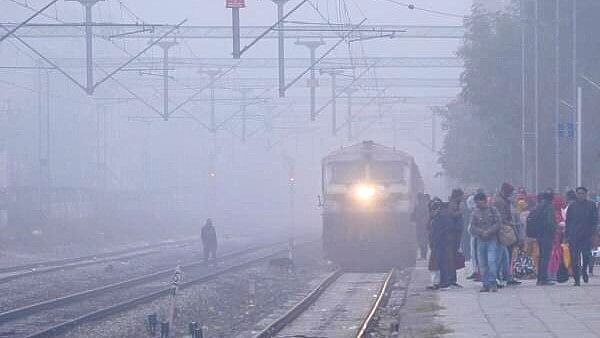 <div class="paragraphs"><p>A train arrives at the Adarsh Nagar railway station amid dense fog, in Ajmer.</p></div>