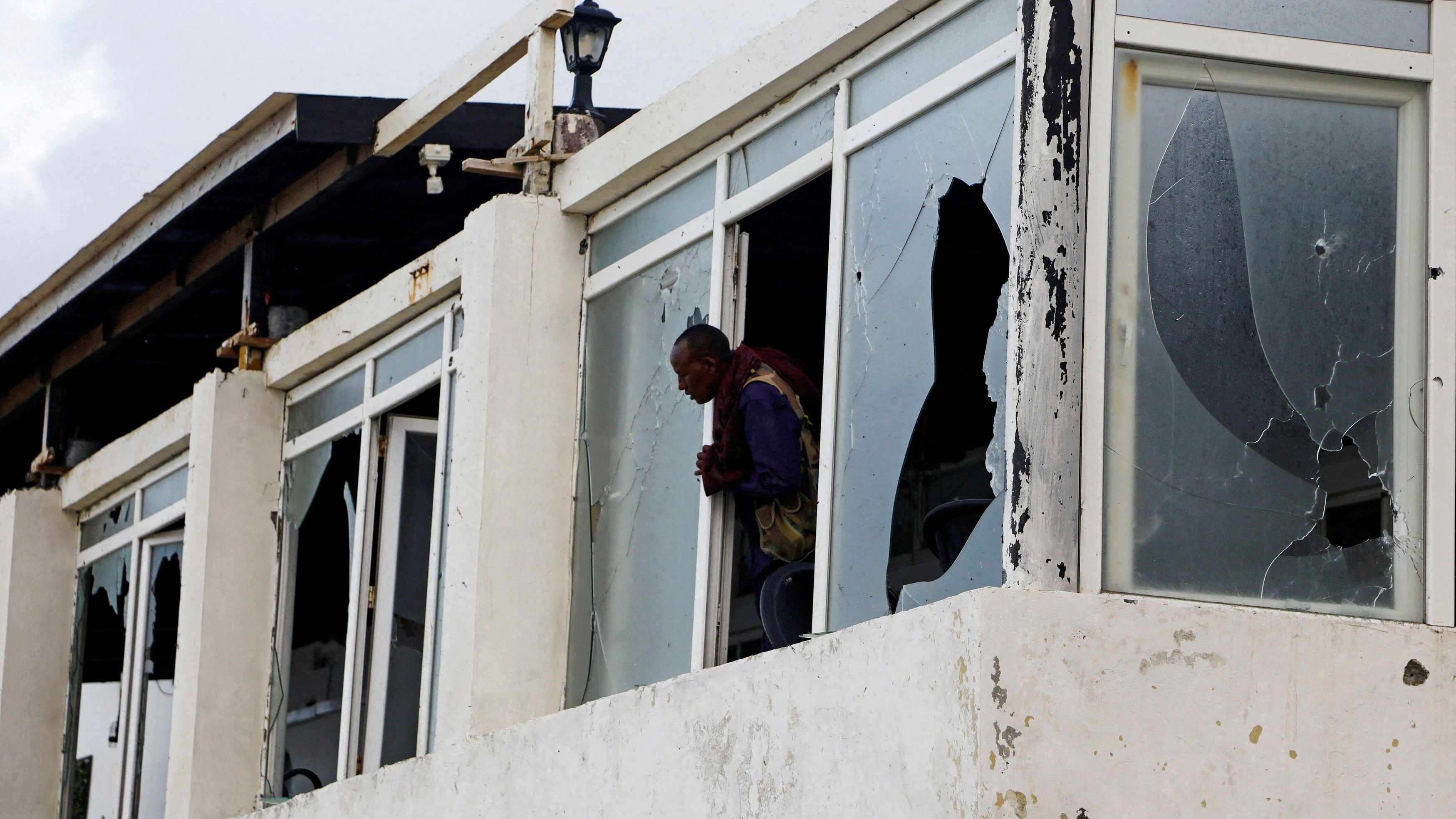 <div class="paragraphs"><p>A Somali police officer looks from the broken windows of the Pearl Beach Restaurant following an attack by Al Shabaab militants at the Liido beach in Mogadishu, Somalia from June 2023.</p></div>
