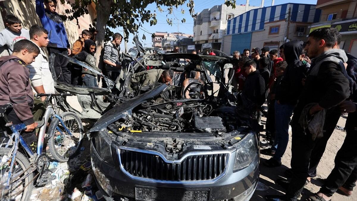 <div class="paragraphs"><p>Palestinians inspect the remains of a car where Palestinian journalist Hamza Al-Dahdouh was killed along with another journalist in an Israeli strike, in Rafah in the southern Gaza Strip, January 7, 2024.</p></div>