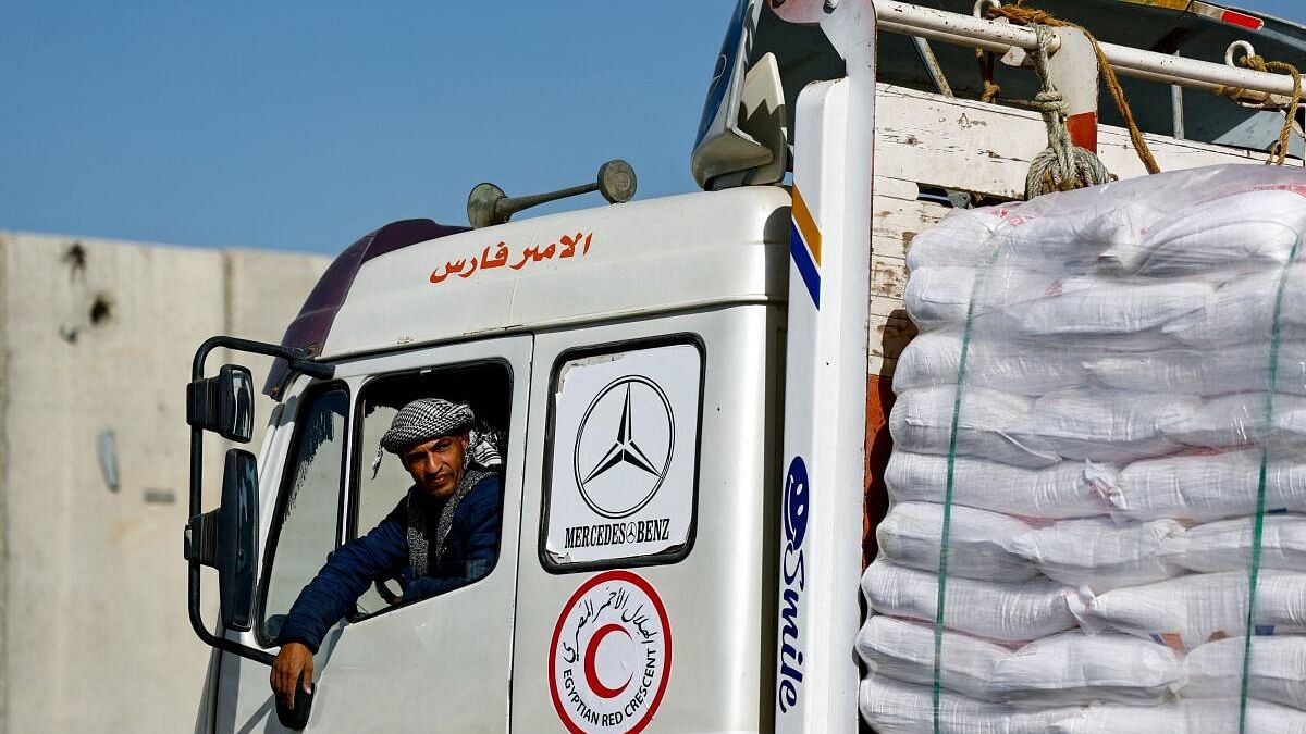 <div class="paragraphs"><p>An Egyptian aid truck driver with the Egyptian Red Crescent returns to his truck after cargo inspection, before going to Gaza.</p></div>