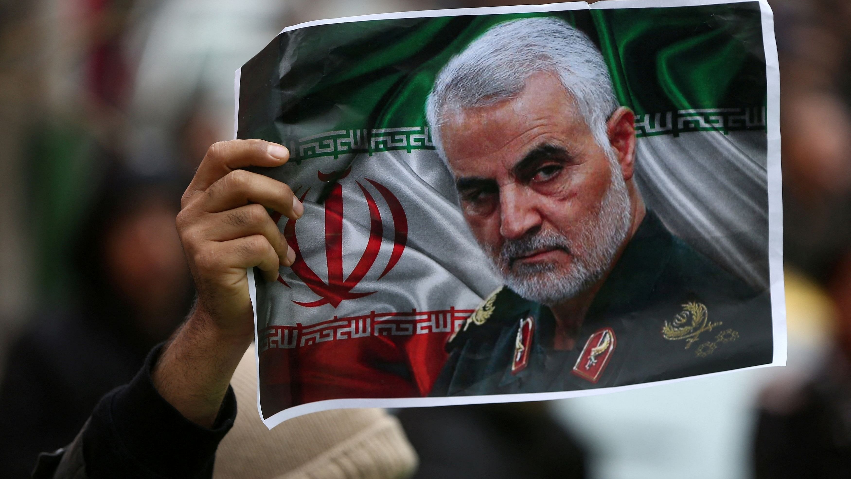 <div class="paragraphs"><p>An Iranian holds a picture of late General Qassem Soleimani, head of the elite Quds Force, who was killed in an air strike at Baghdad airport, as people gather to mourn him in Tehran, Iran</p></div>