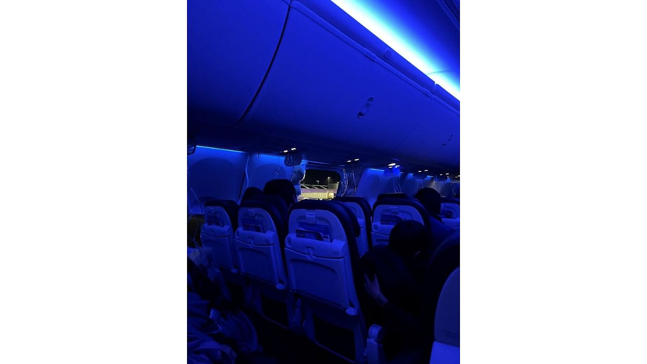 <div class="paragraphs"><p>People sit on a plane next to a missing window and portion of a side wall of an Alaska Airlines Flight 1282, in Portland, Oregon.</p></div>