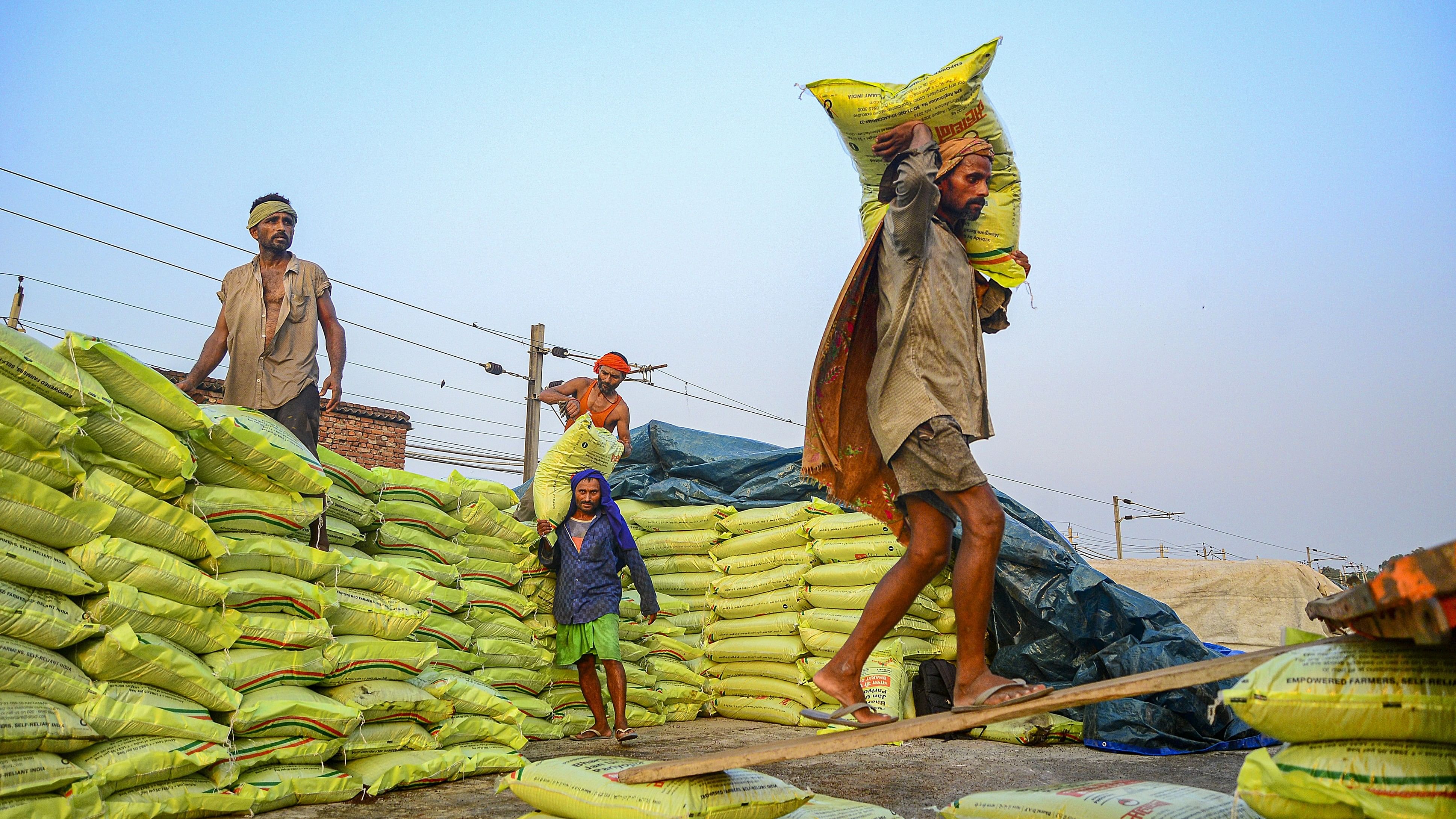 <div class="paragraphs"><p>Labourers load sacks of compost for agricultural use, at a warehouse.</p></div>