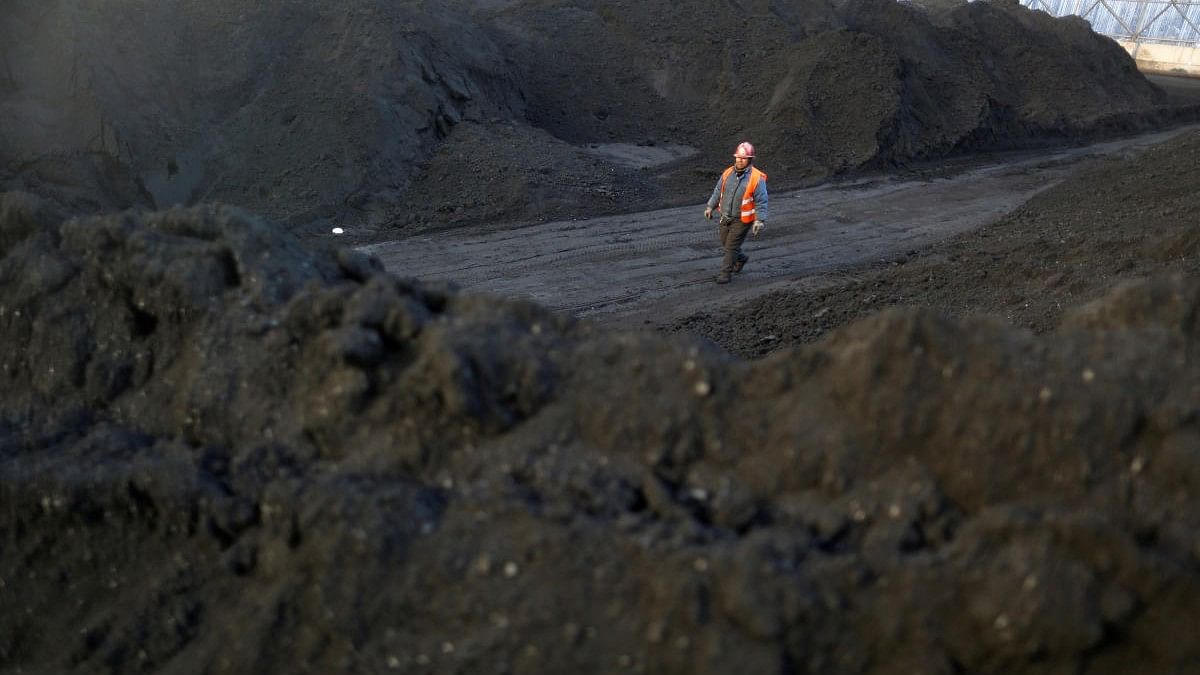 <div class="paragraphs"><p>A worker walks past coal piles at a coal coking plant in China.</p></div>