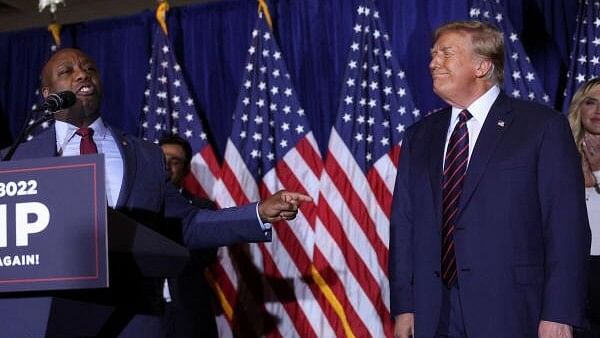 <div class="paragraphs"><p>Republican presidential candidate and former US President Donald Trump reacts as US Senator Tim Scott (R-SC) speaks during Trump's New Hampshire presidential primary election night watch party, in Nashua, New Hampshire, US, January 23, 2024.</p></div>